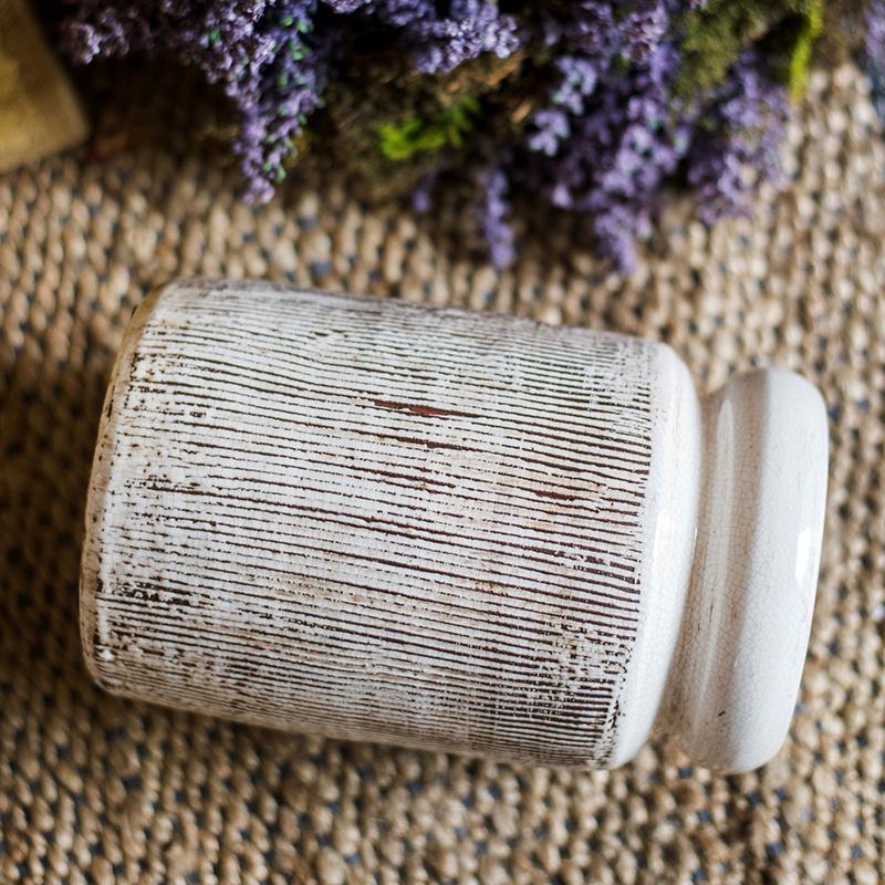 Handmade glazed ceramic vase with abstract brown stripes on a white background, showcasing a unique design and textured finish.