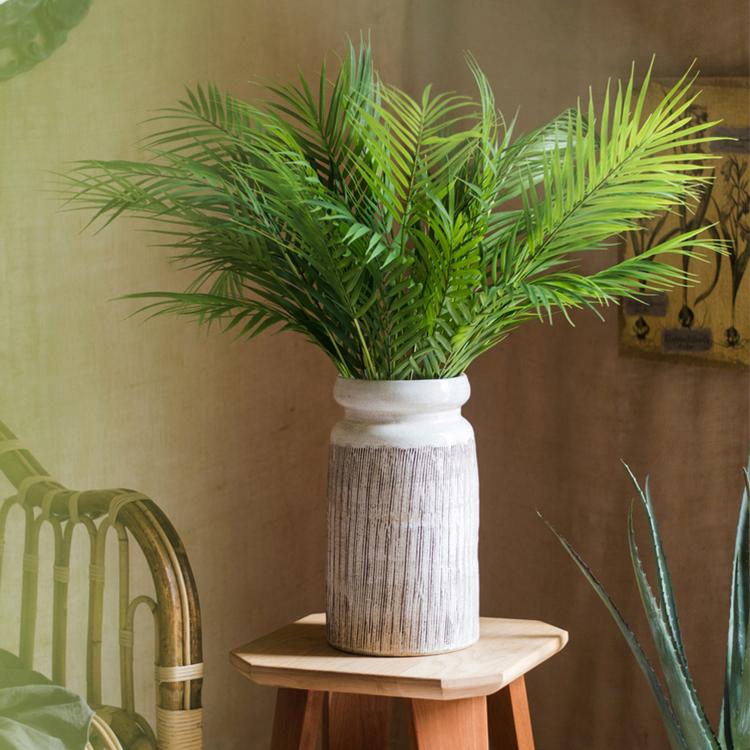 Handmade glazed ceramic vase with abstract brown stripes on a white background, showcasing a unique design and textured finish.