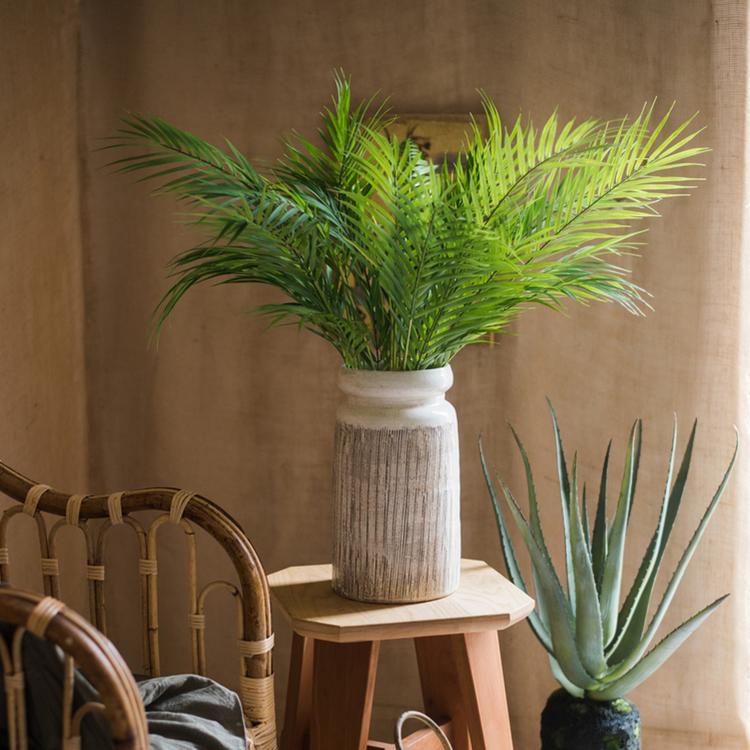 Handmade glazed ceramic vase with abstract brown stripes on a white background, showcasing a unique design and textured finish.