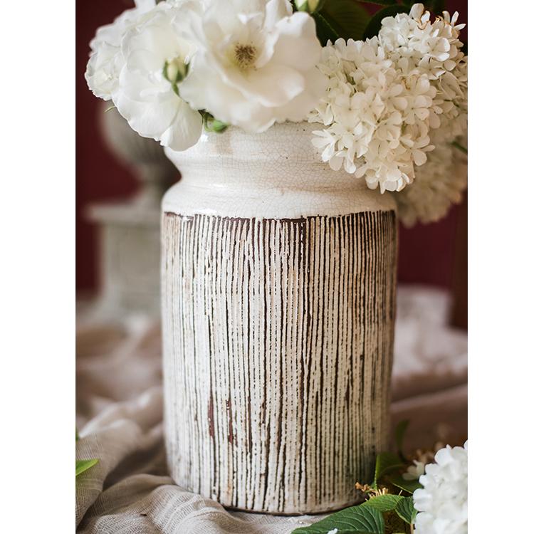 Handmade glazed ceramic vase with abstract brown stripes on a white background, showcasing a unique design and textured finish.