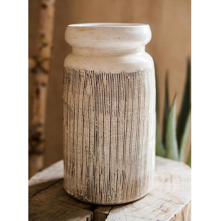 Handmade glazed ceramic vase with abstract brown stripes on a white background, showcasing a unique design and textured finish.