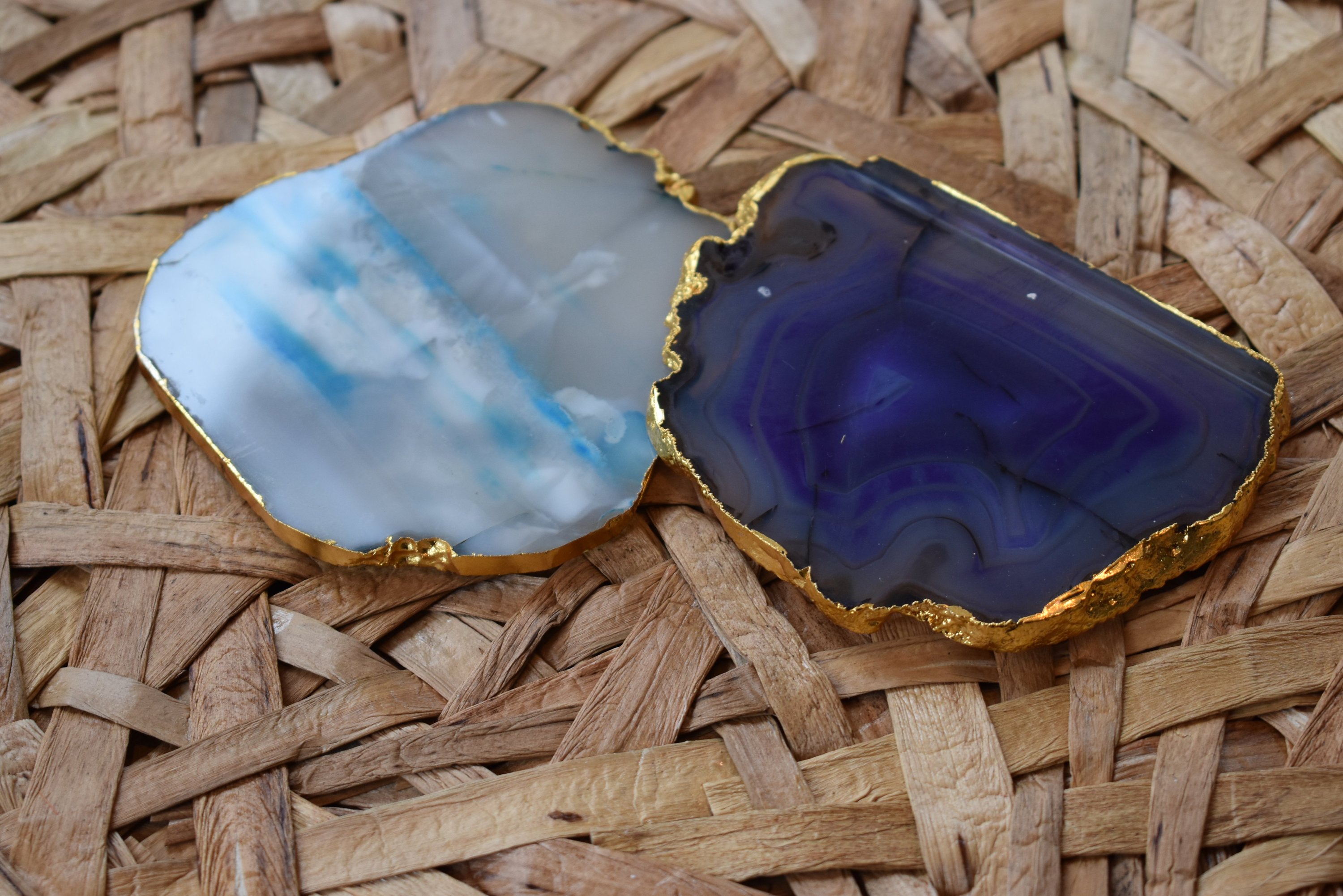 Set of four gnarled agate coasters with gold trim, showcasing unique natural patterns and vibrant colors.