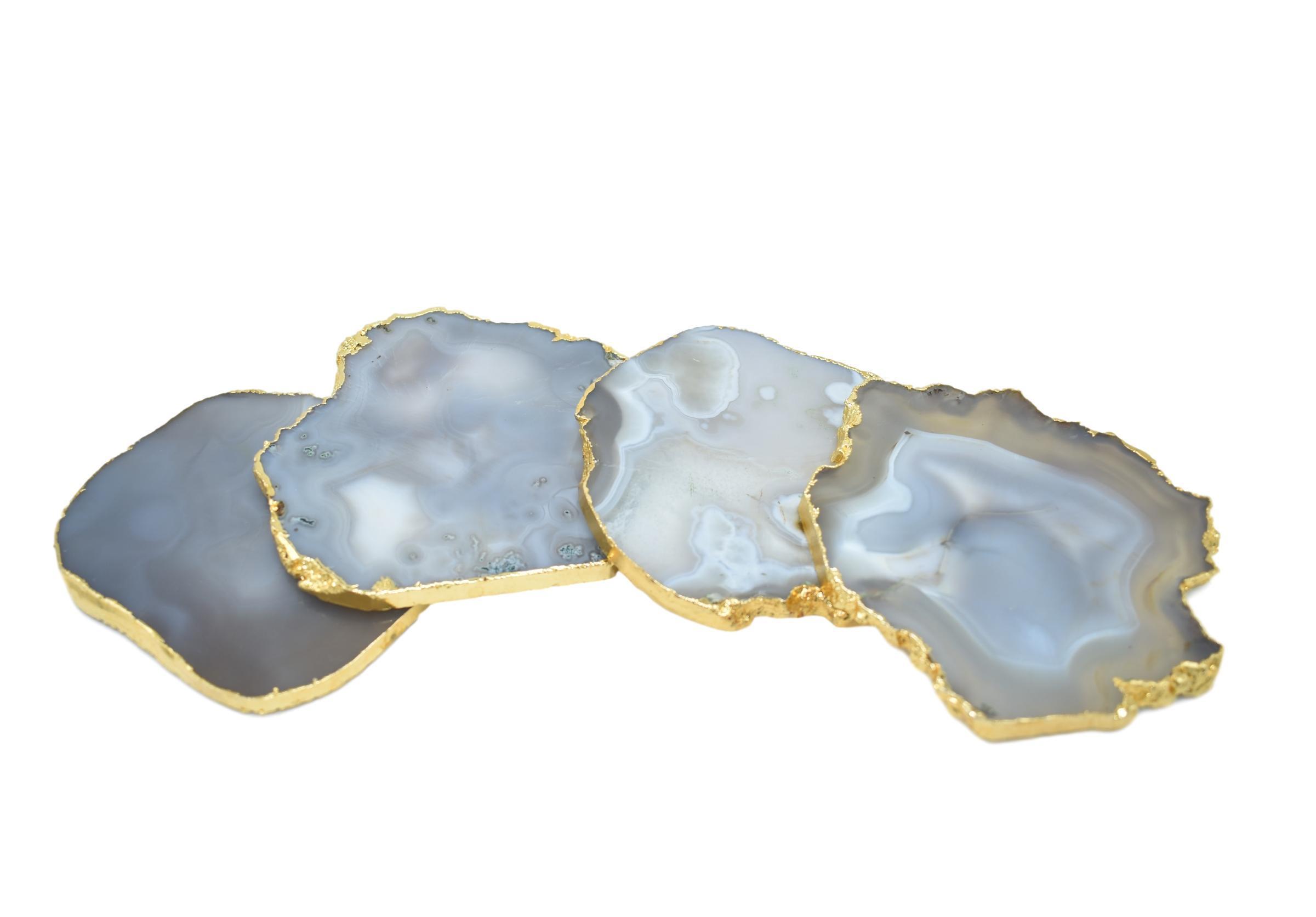 Set of four gnarled agate coasters with gold trim, showcasing unique natural patterns and vibrant colors.