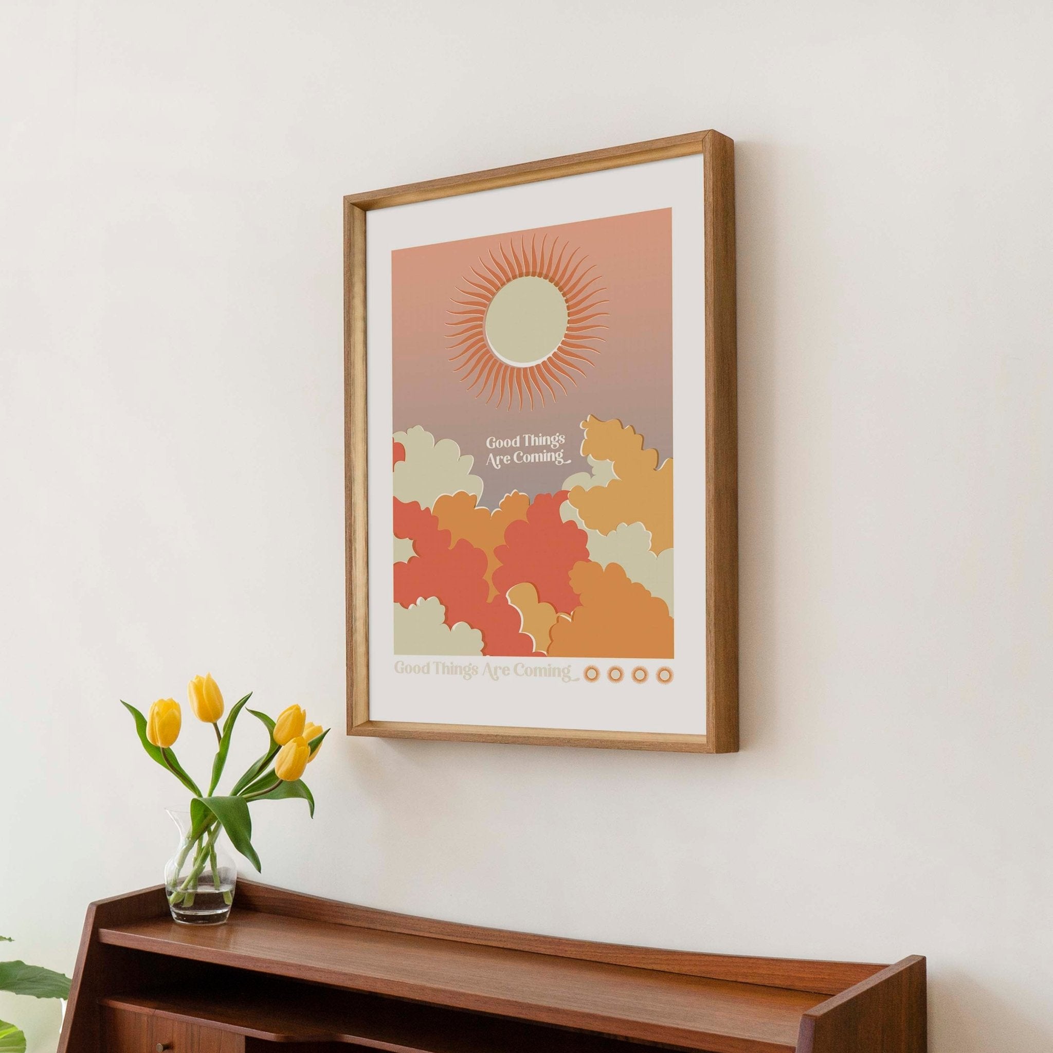 Good Things Are Coming art print featuring retro word art with sun and cloud imagery in warm colors.