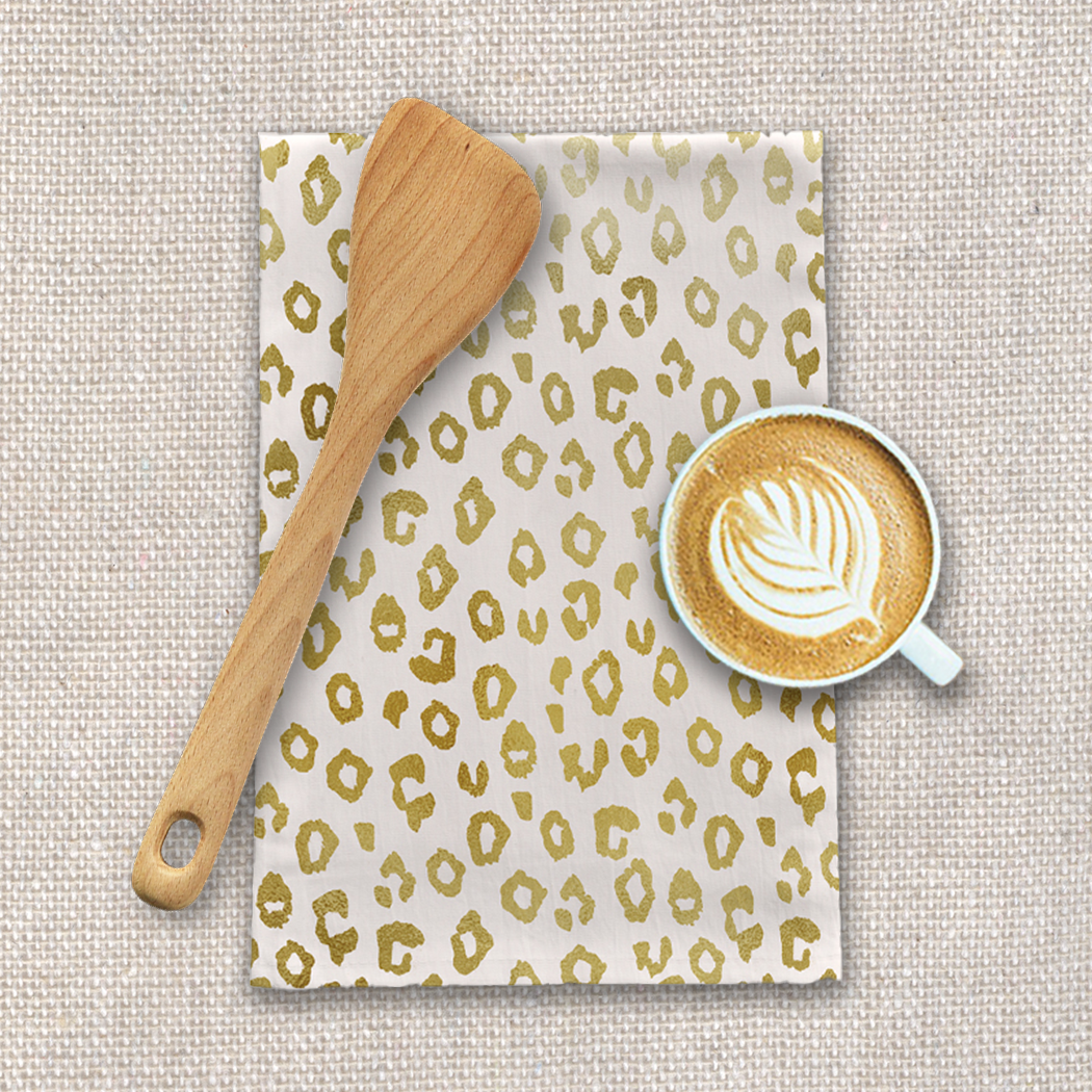 Gold Leopard Print Tea Towel made of cotton twill, featuring a stylish design and hemmed edges, perfect for kitchen use.