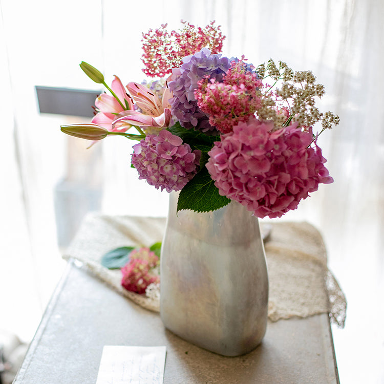 A beautifully crafted Gradient Color Art Glass Vase featuring a unique blend of pink and cream colors, showcasing its hand-blown design.