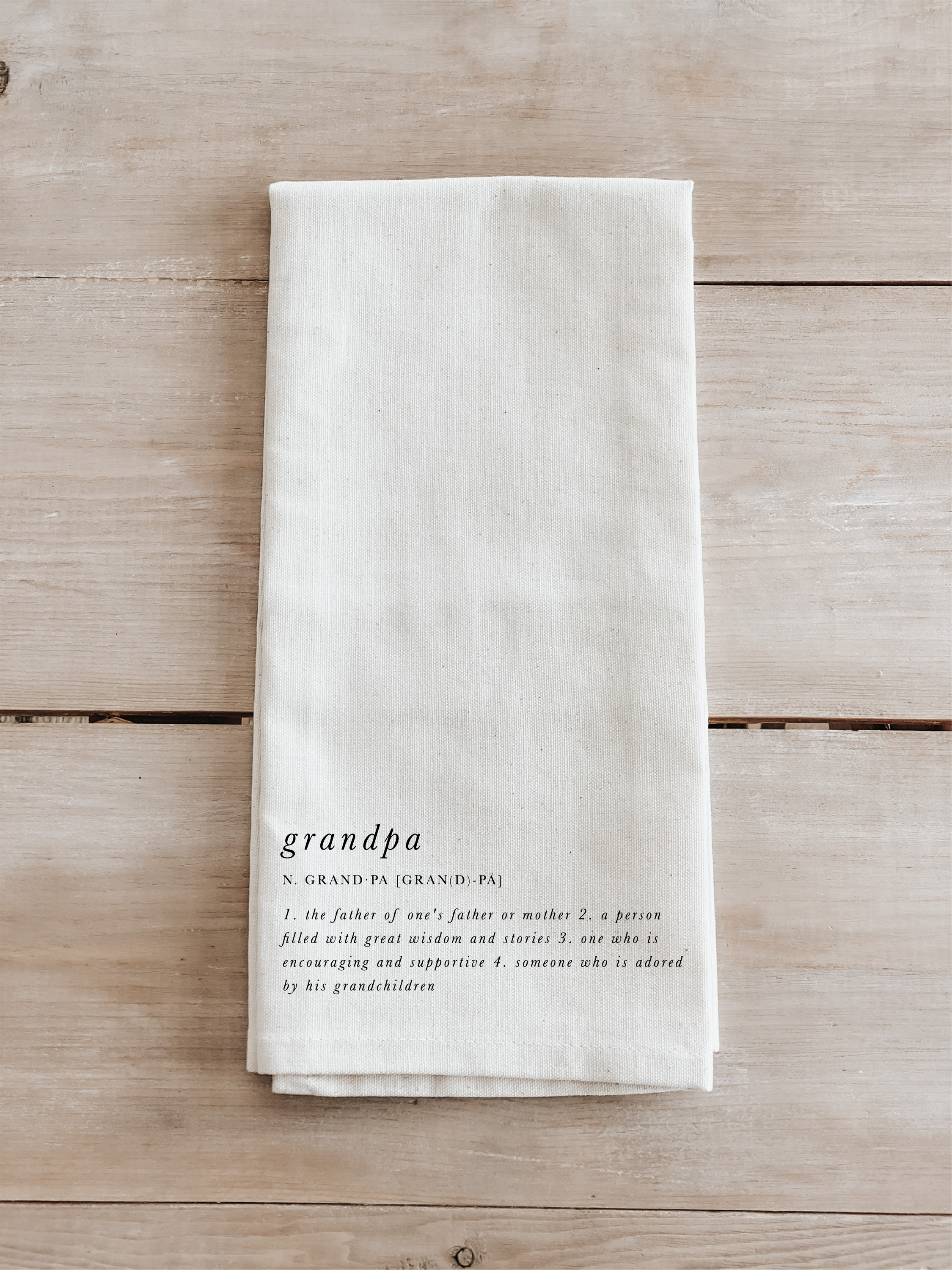 A beautifully designed Grandpa Definition Tea Towel made from 100% organic cotton, featuring eco-friendly inks in white and natural colors.