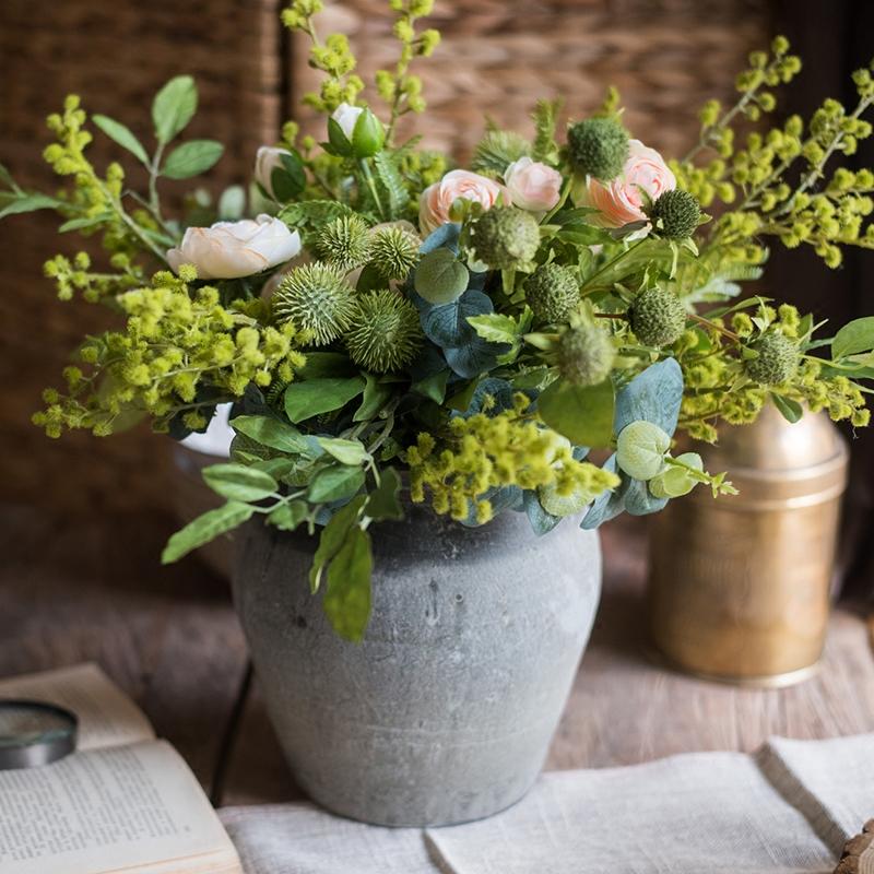 A beautiful Greenery White Rose Bouquet arranged in a handmade gray ceramic pottery, featuring lifelike white roses and lush greenery.