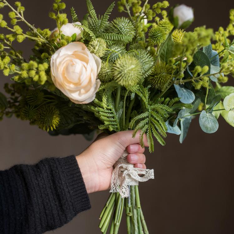 A beautiful Greenery White Rose Bouquet arranged in a handmade gray ceramic pottery, featuring lifelike white roses and lush greenery.