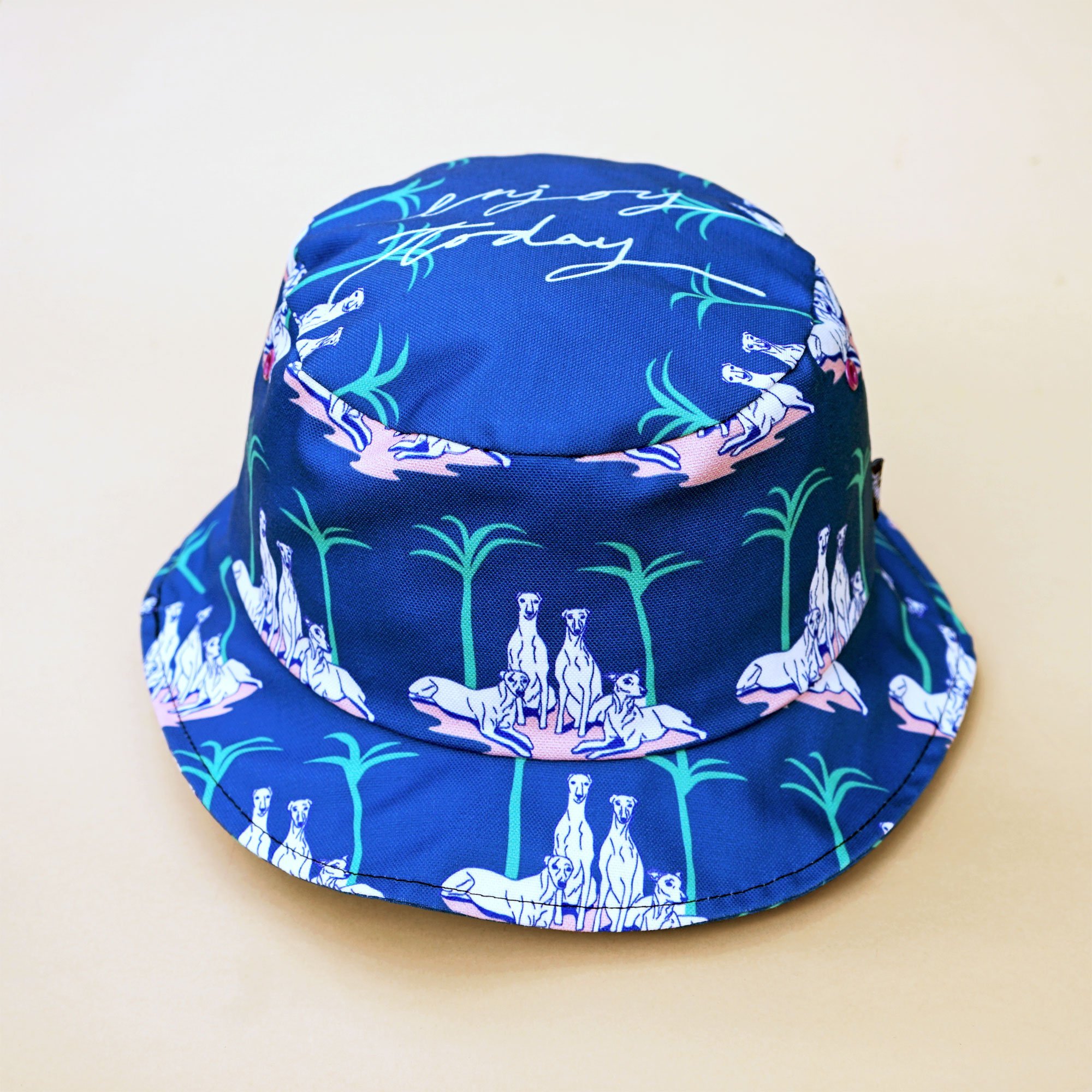 A stylish greyhound and palm tree bucket hat made from cotton canvas, perfect for summer outings.