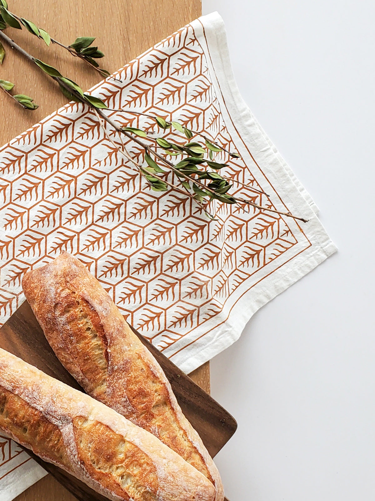 Set of 2 hand screen printed tea towels in natural cotton with artisan designs in light and dark brown.