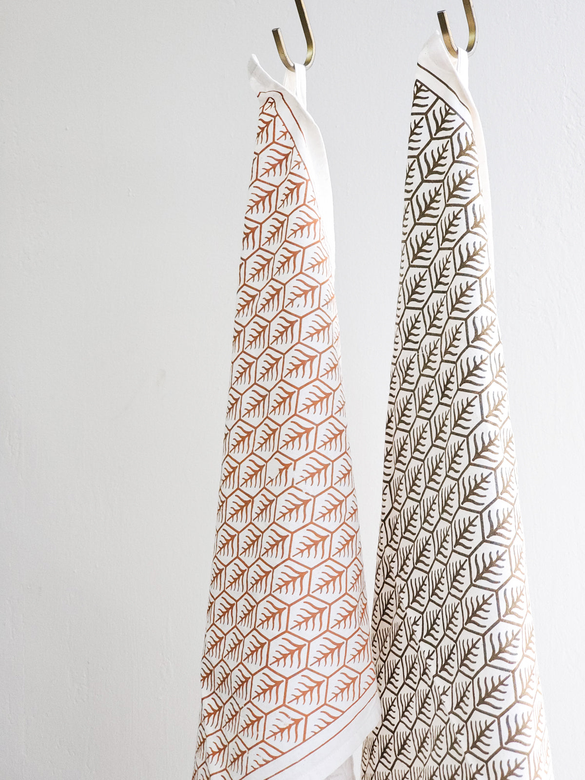 Set of 2 hand screen printed tea towels in natural cotton with artisan designs in light and dark brown.