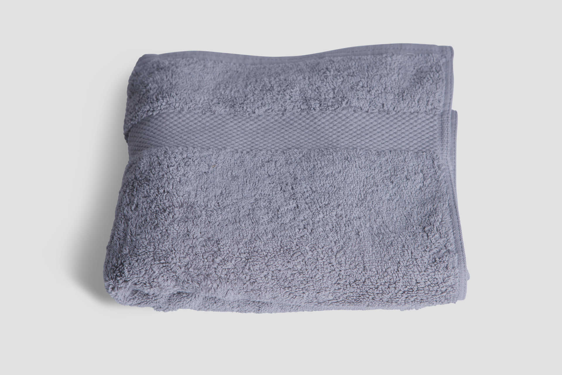 Luxurious grey hand towel made from 700gsm organic cotton, showcasing its plush texture and eco-friendly design.