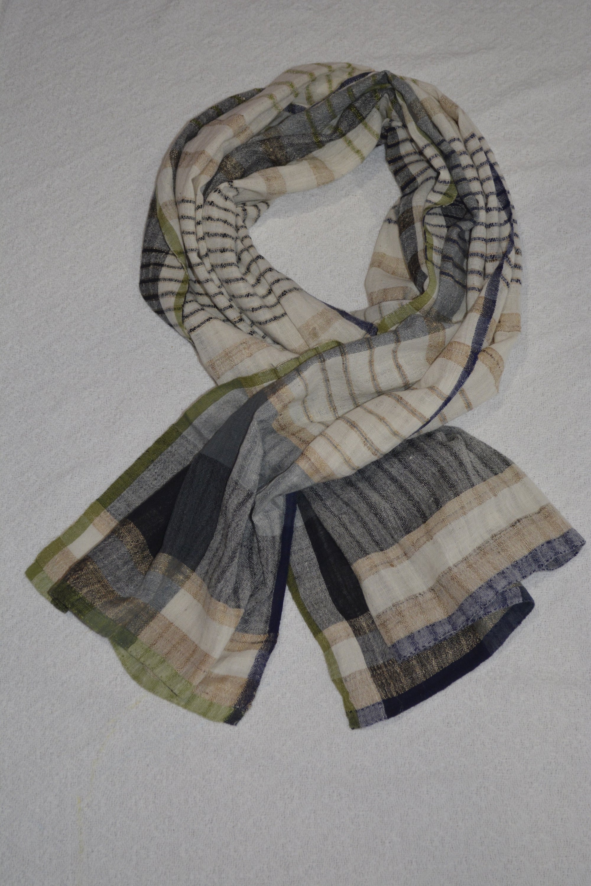 A collection of hand woven cotton scarves in various colors and patterns, showcasing the intricate craftsmanship and soft texture of Khadi cotton.