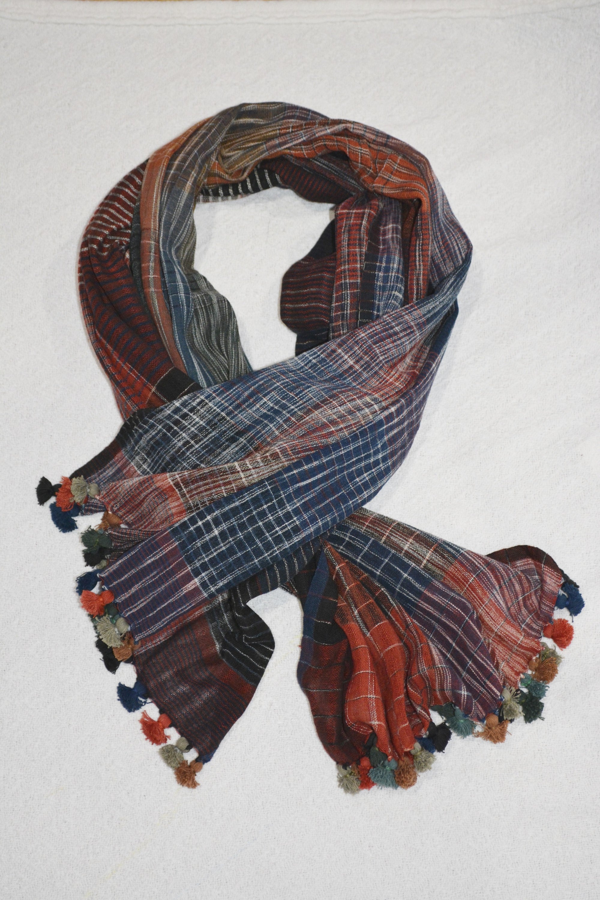 A collection of hand woven cotton scarves in various colors and patterns, showcasing the intricate craftsmanship and soft texture of Khadi cotton.