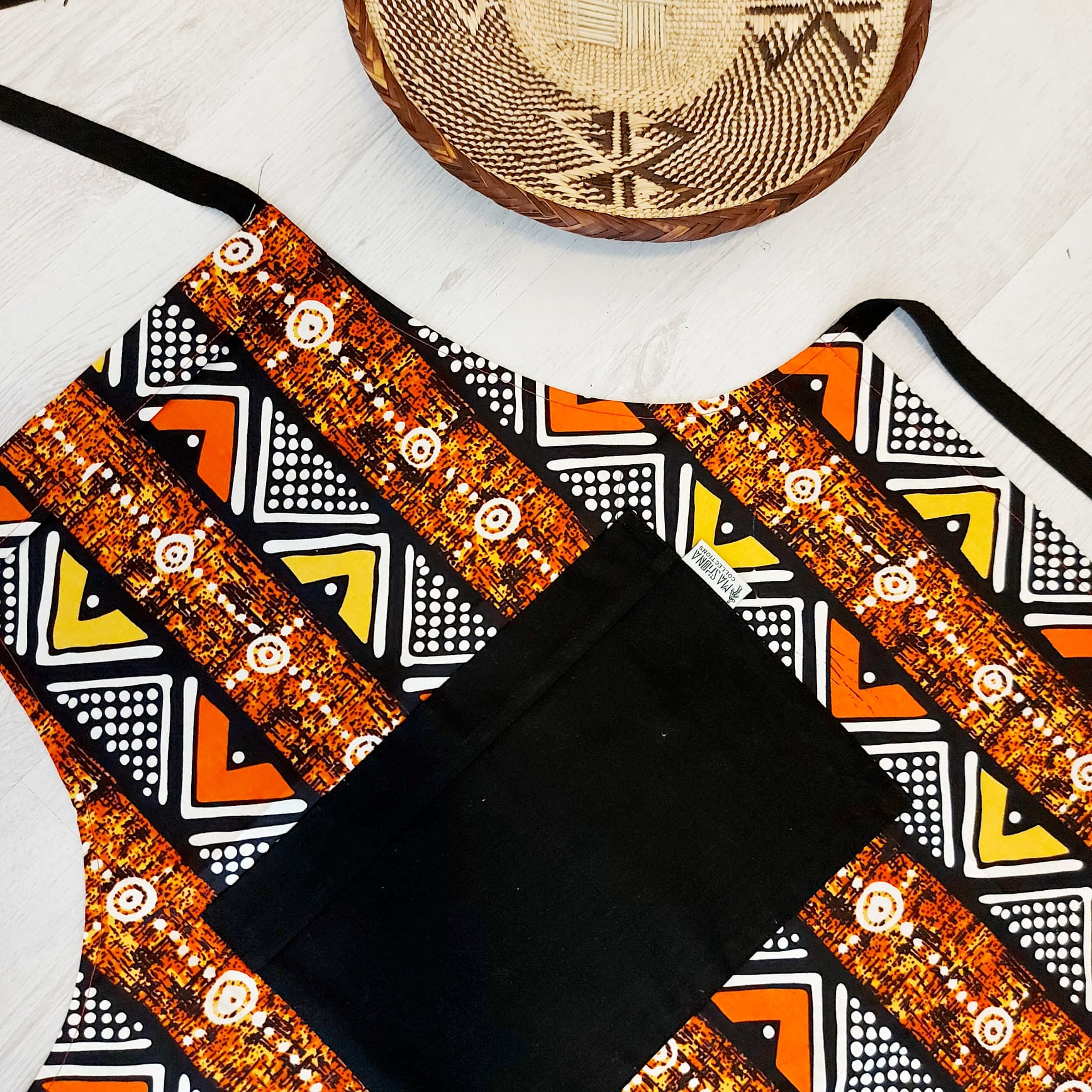 A vibrant Handmade African Print Apron featuring a traditional 'Bogolan' design, made from 100% cotton with a convenient pocket.