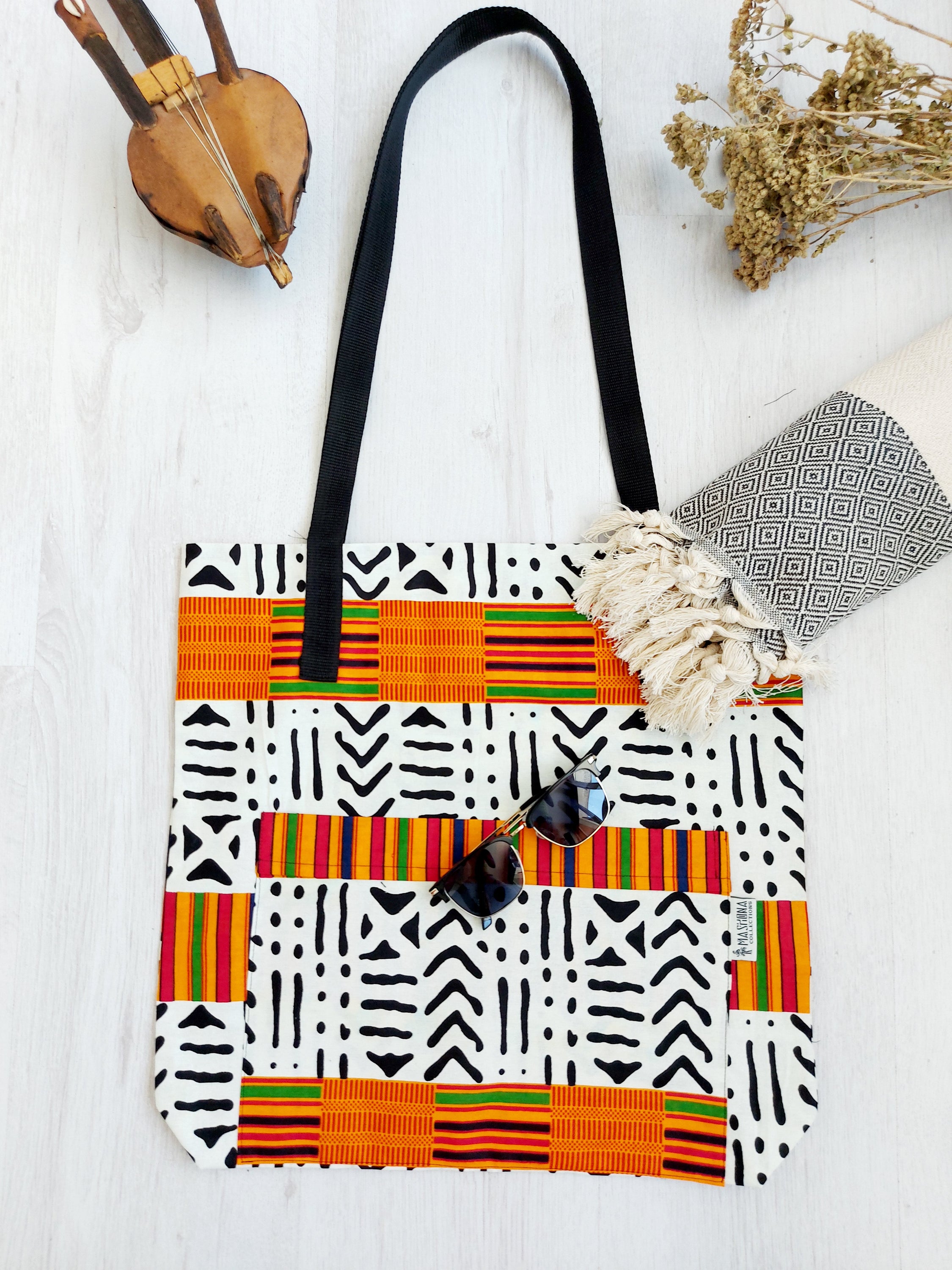 Handmade African Print Tote Bag featuring vibrant patterns, long handles, and spacious interior, perfect for shopping or beach outings.