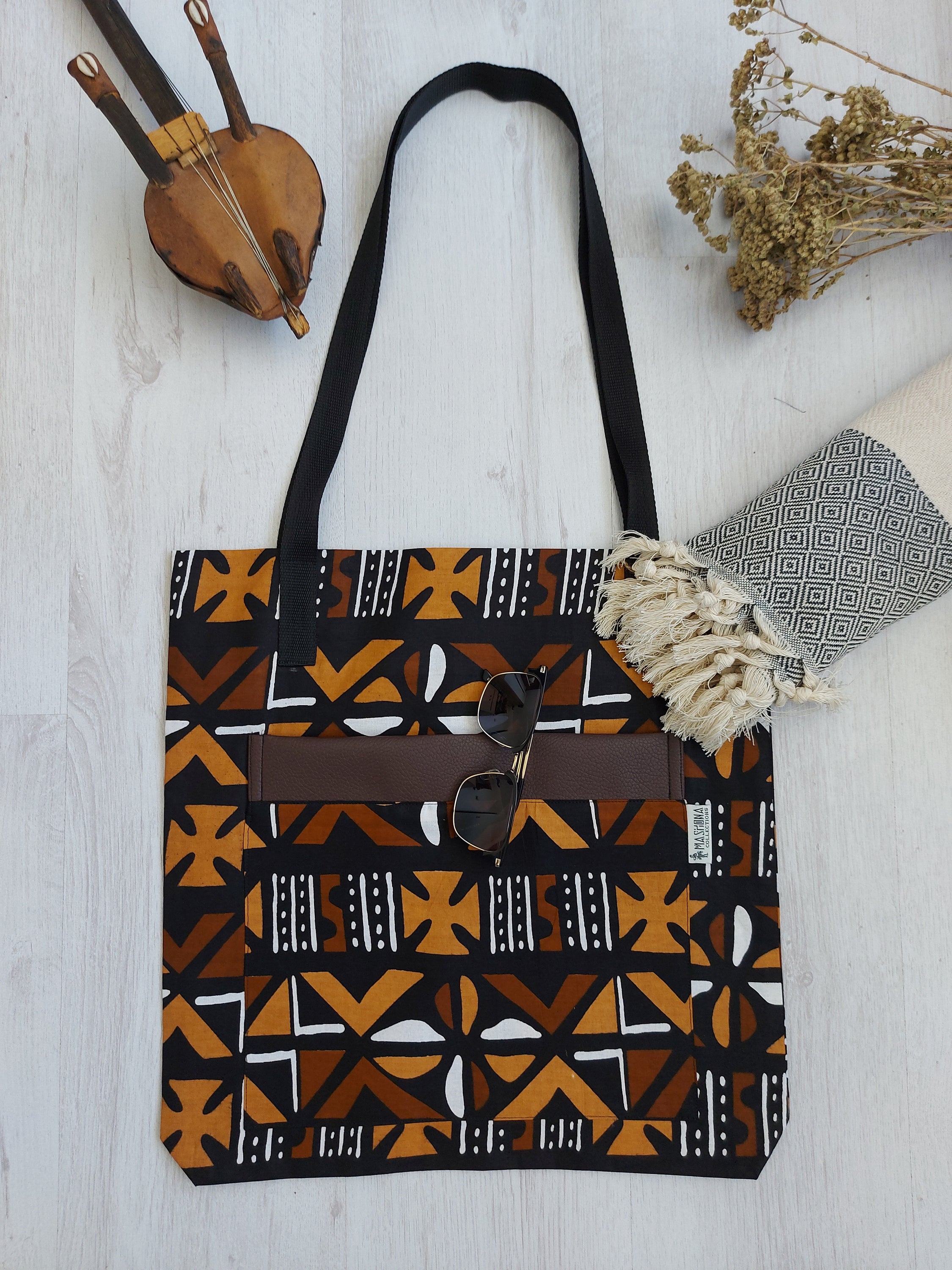 Handmade African Print Tote Bag featuring vibrant patterns, long handles, and spacious interior, perfect for shopping or beach outings.