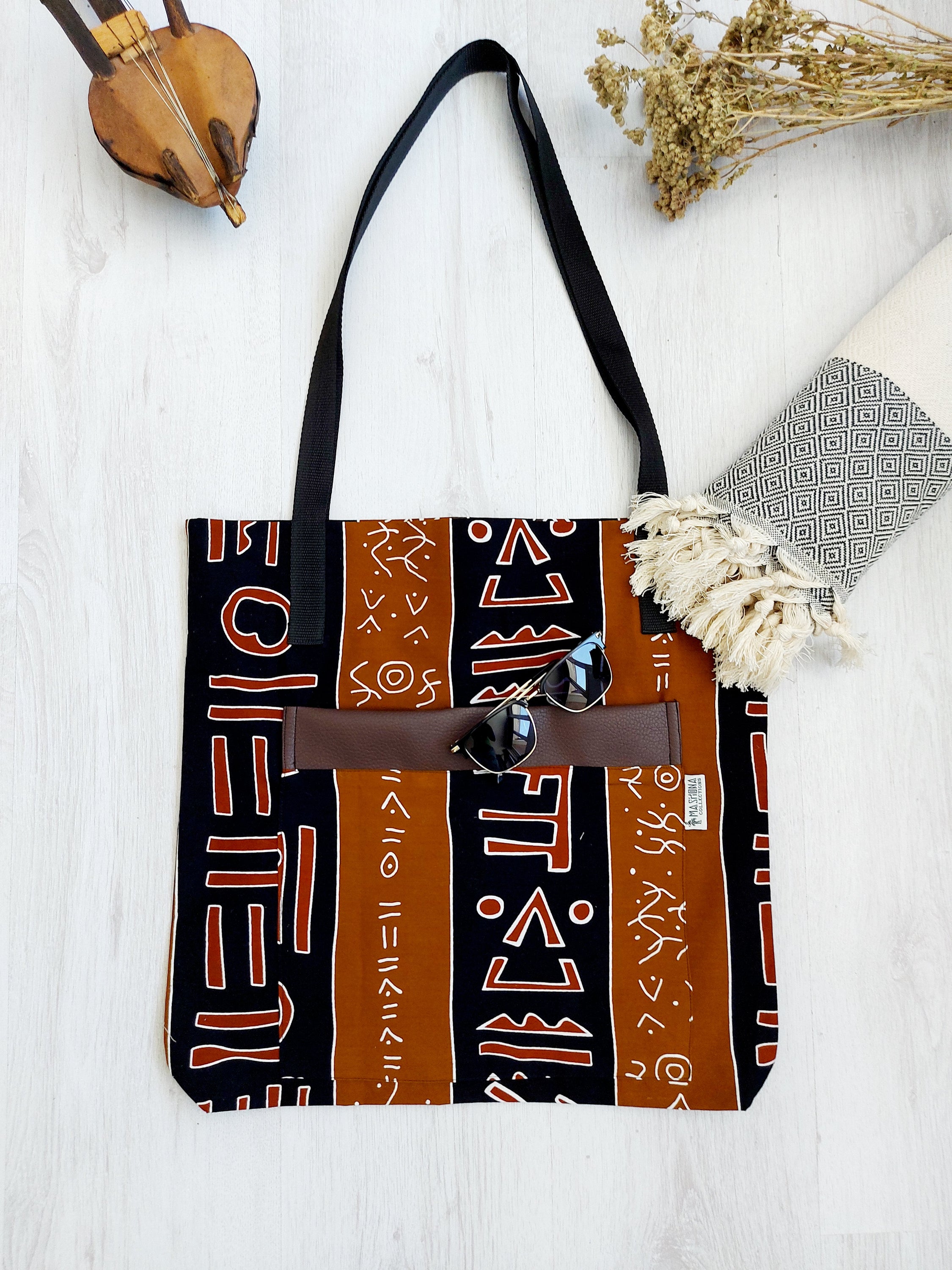 Handmade African Print Tote Bag featuring vibrant patterns, long handles, and spacious interior, perfect for shopping or beach outings.