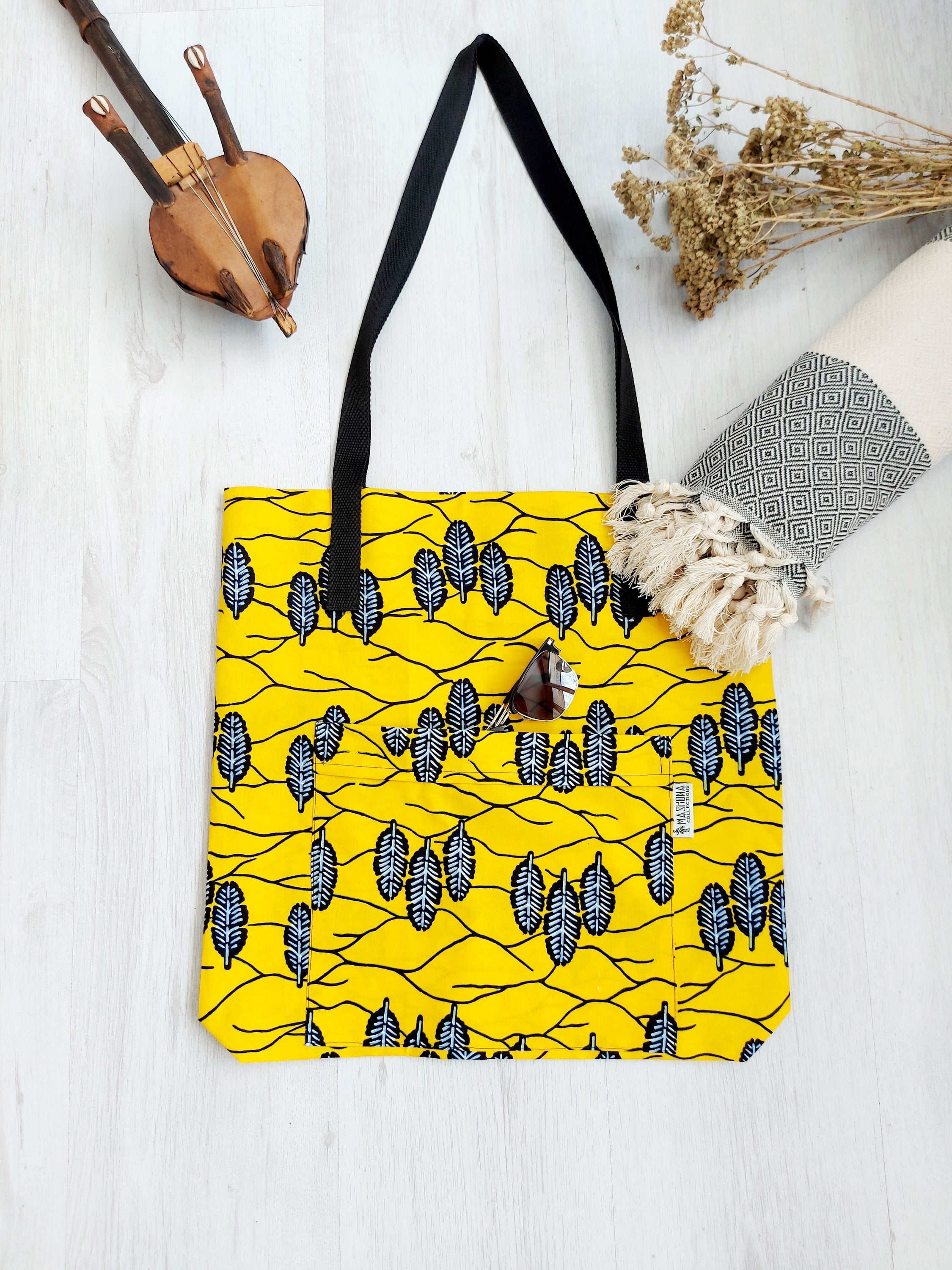 Handmade African Print Tote Bag featuring vibrant patterns, long handles, and eco-friendly cotton fabric, perfect for shopping and beach outings.