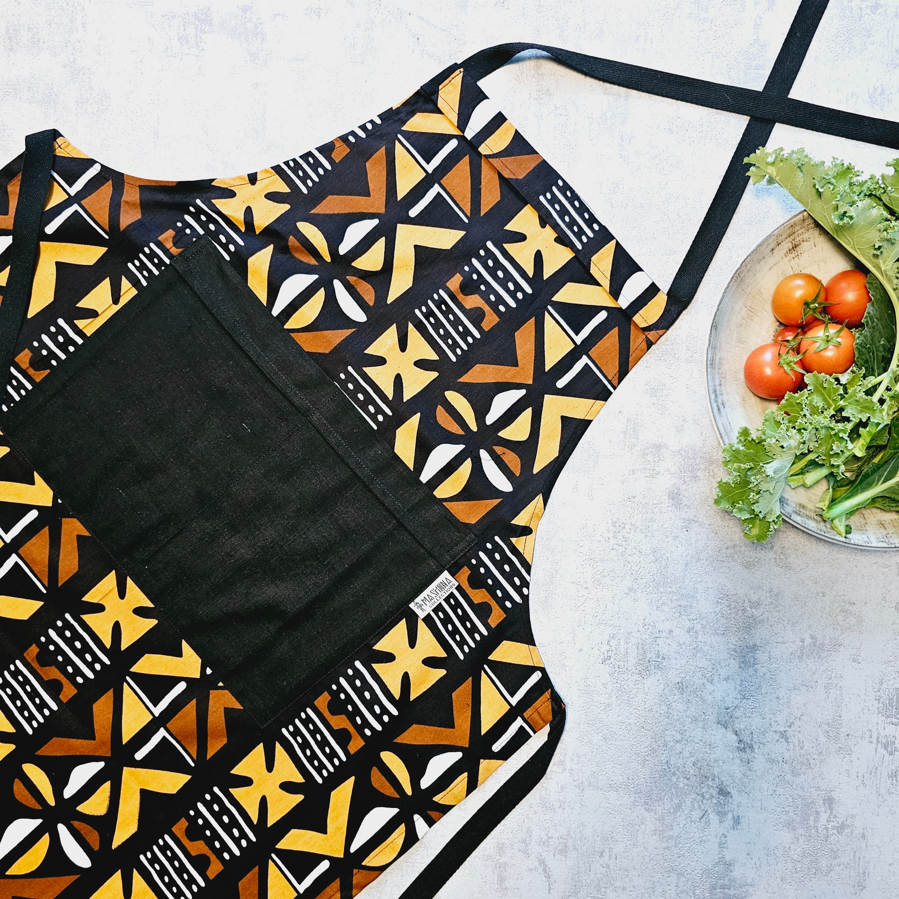 Handmade African print apron featuring vibrant Bogolan design, made from 100% cotton with a pocket.