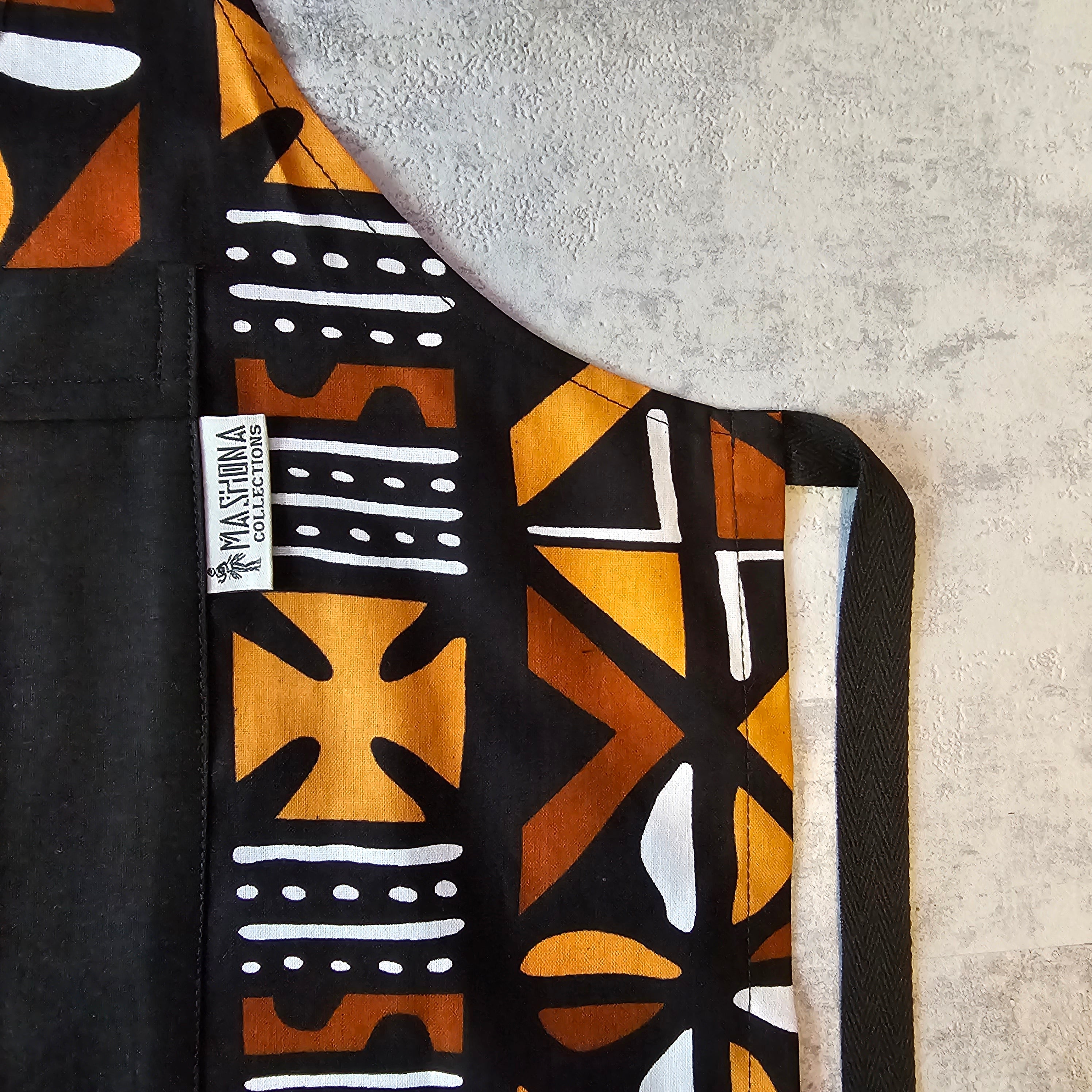 Handmade African print apron featuring vibrant Bogolan design, made from 100% cotton with a pocket.