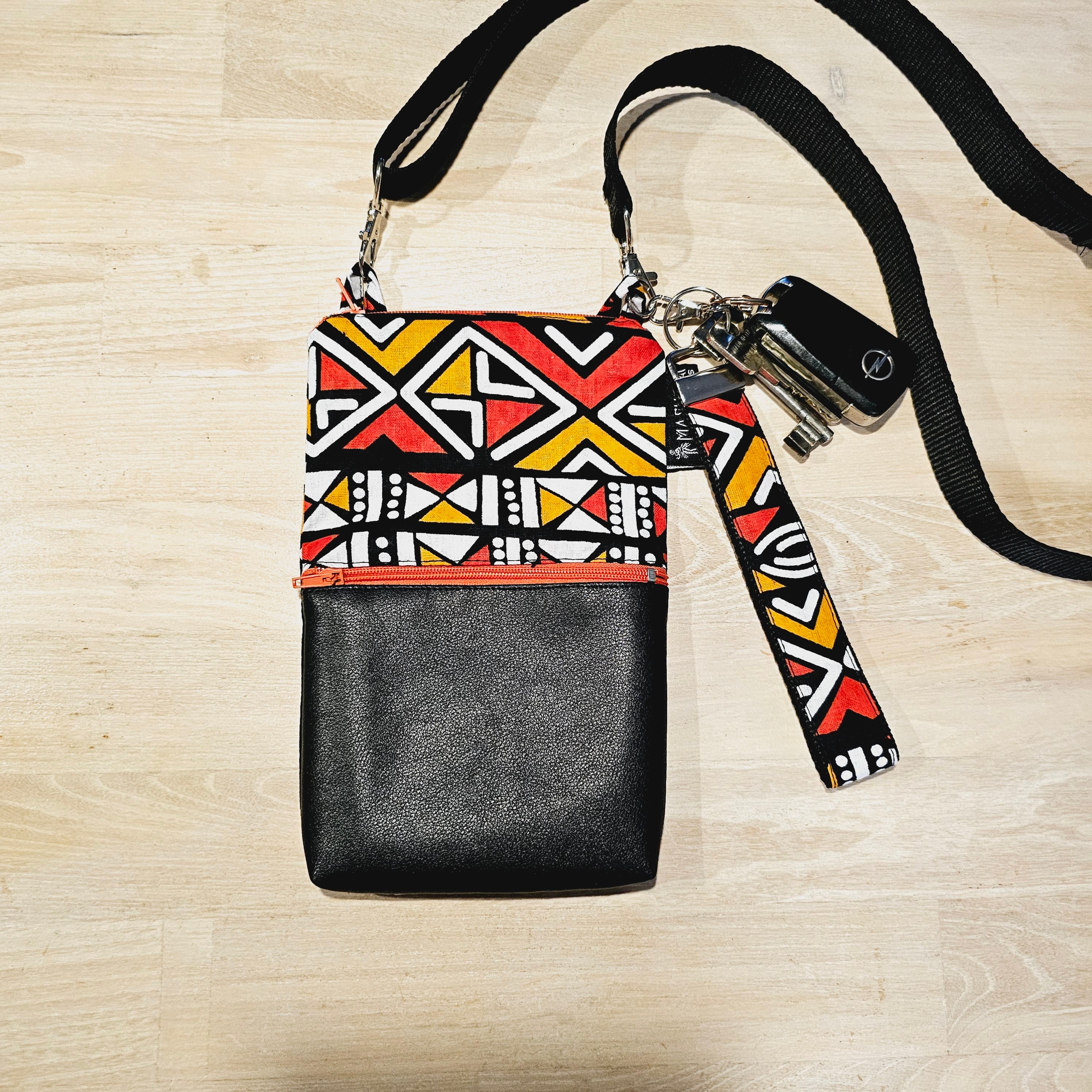 Handmade phone bag featuring vibrant African Ankara print fabric with vegan leather details and detachable wristlet key fob.