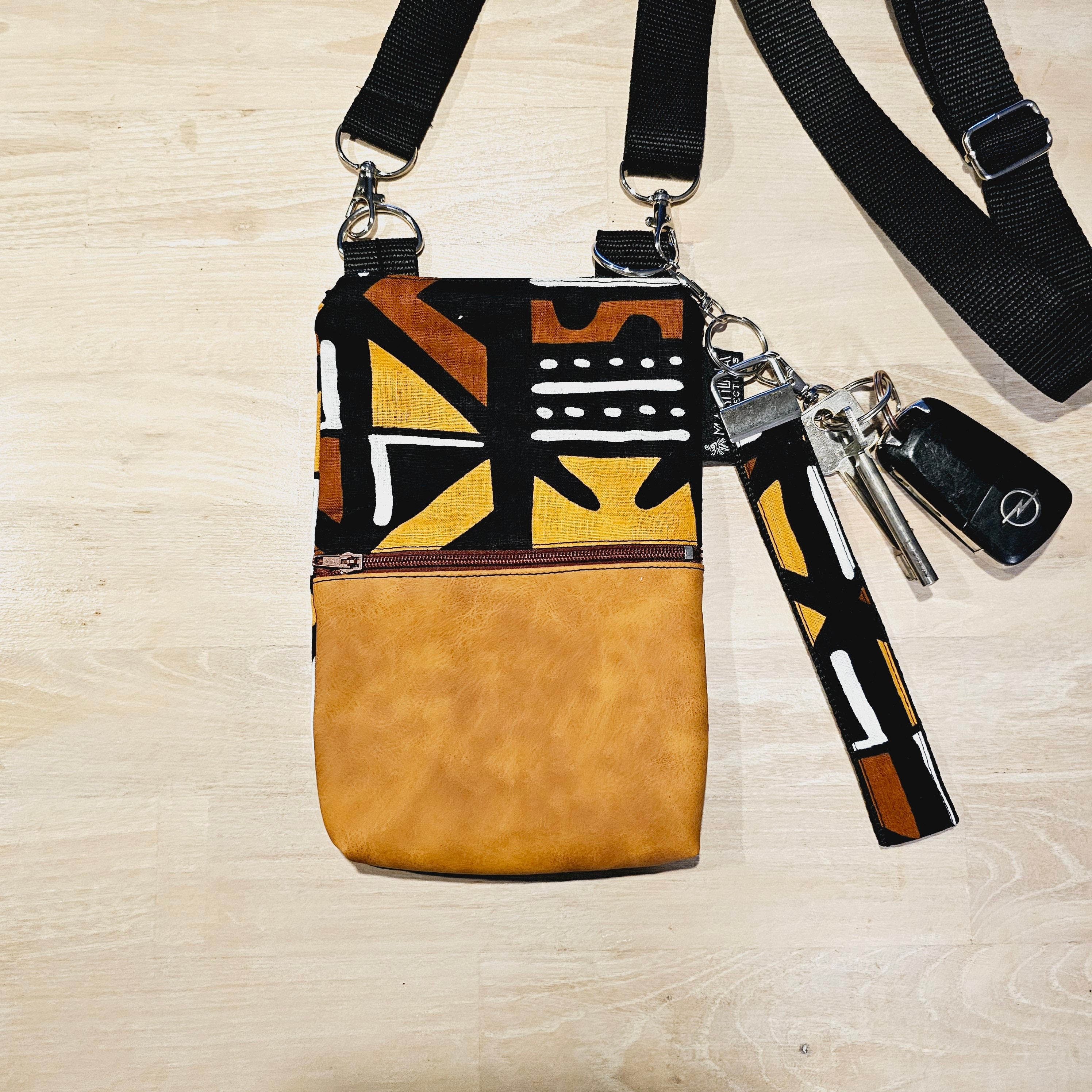 Handmade phone bag featuring vibrant African Ankara print fabric with vegan leather details and detachable wristlet key fob.