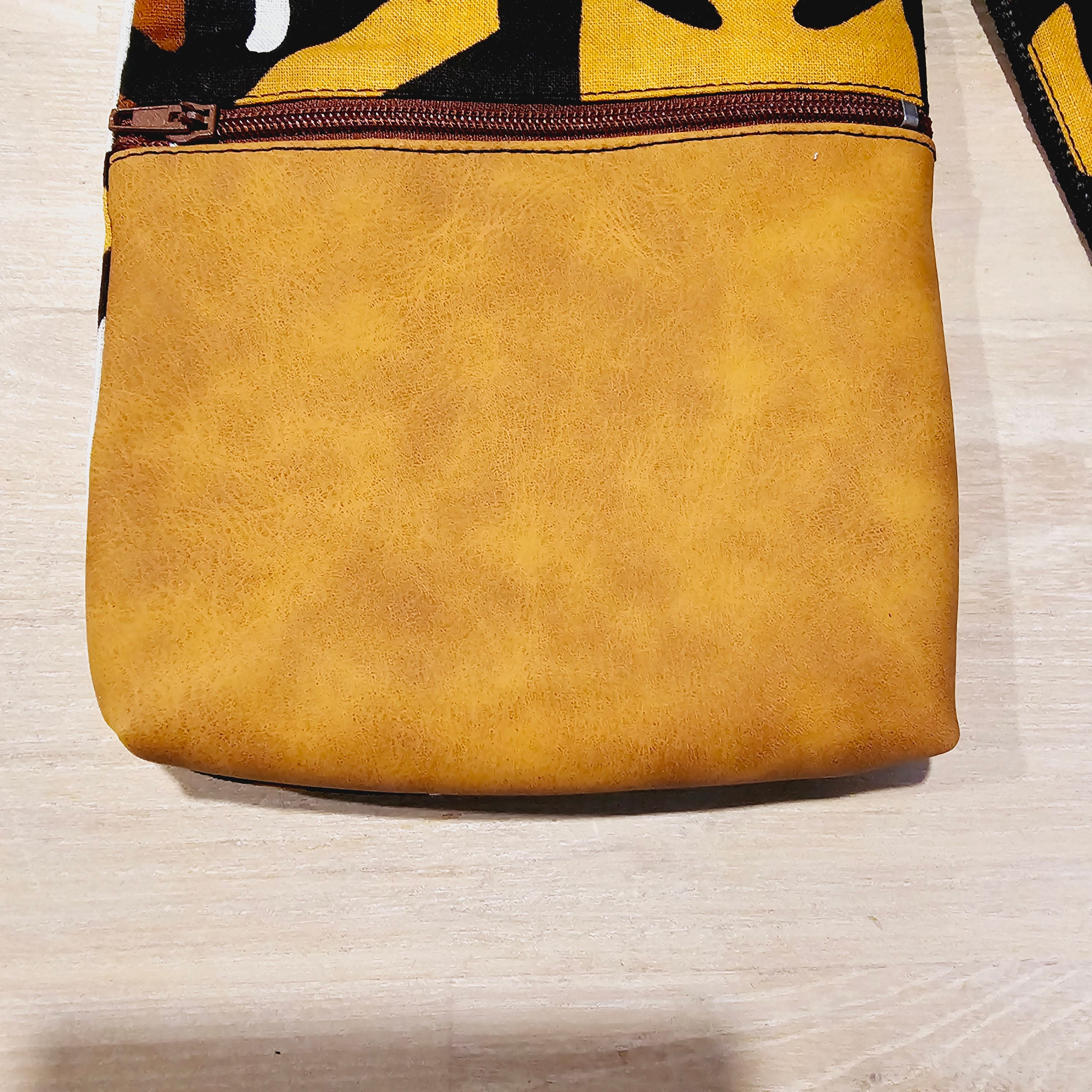 Handmade phone bag featuring vibrant African Ankara print fabric with vegan leather details and detachable wristlet key fob.