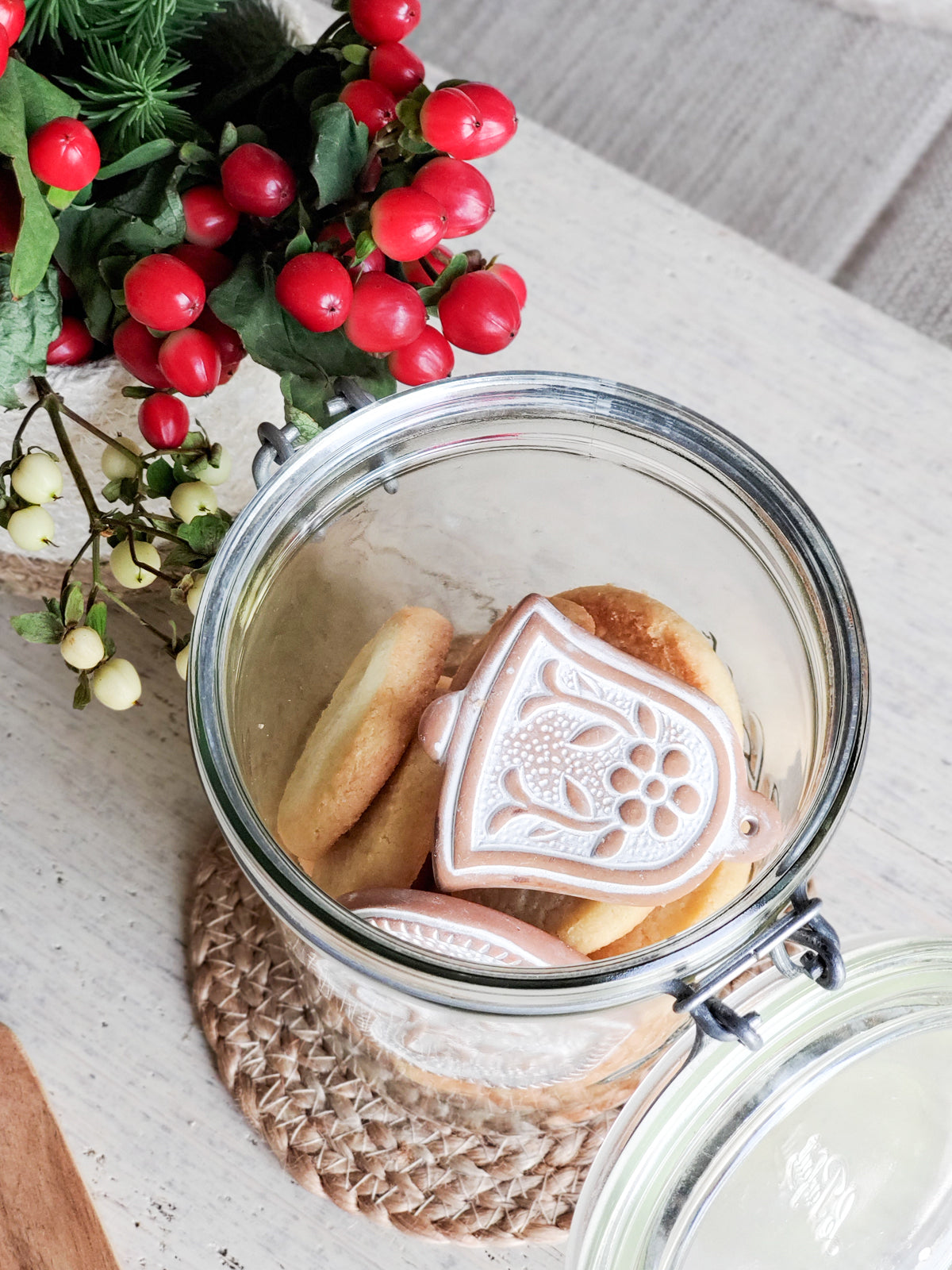 Handmade terracotta sugar saver ornament with a natural jute rope, displayed in a green drawstring pouch, perfect for holiday gifting.