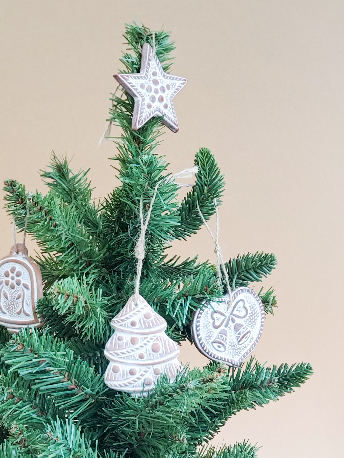 Handmade terracotta sugar saver ornament with a natural jute rope, displayed in a green drawstring pouch, perfect for holiday gifting.