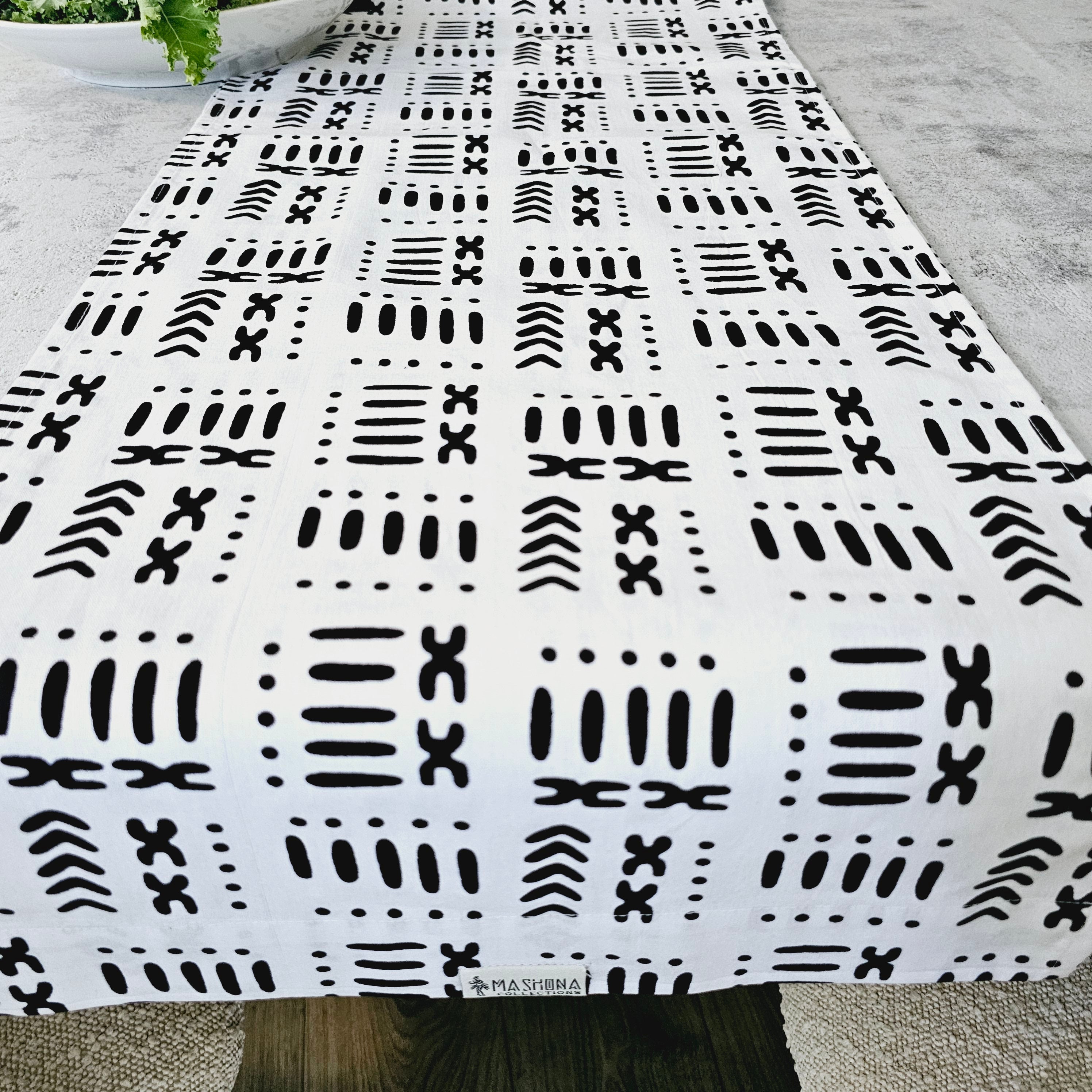 A vibrant handmade table runner featuring unique African prints, available in multiple sizes, elegantly draped over a dining table.