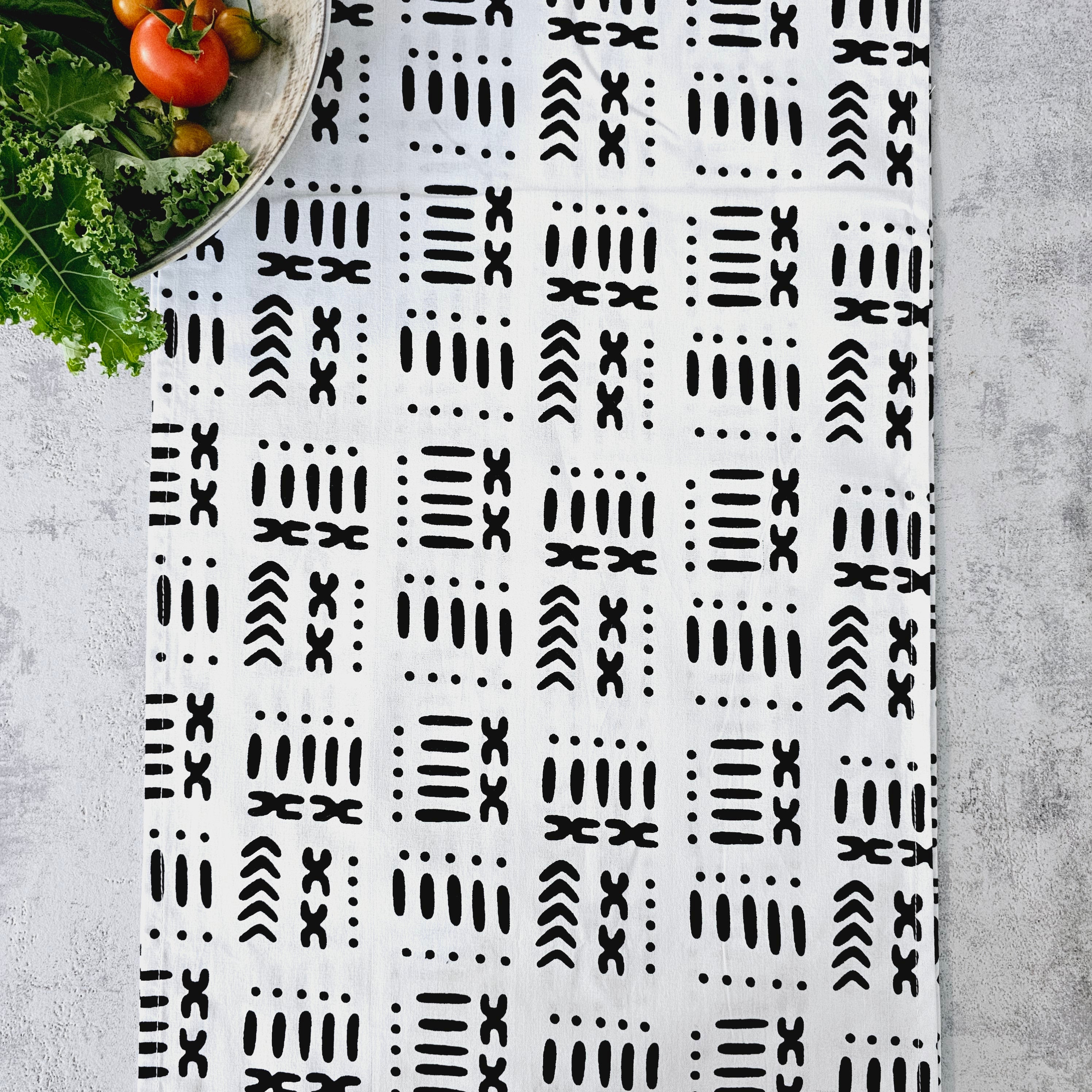 A vibrant handmade table runner featuring unique African prints, available in multiple sizes, elegantly draped over a dining table.