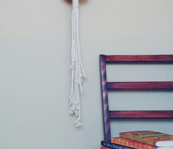 A beautifully crafted macrame plant hanger made from 100% natural cotton rope, showcasing a stylish design with tassels, perfect for indoor plants.