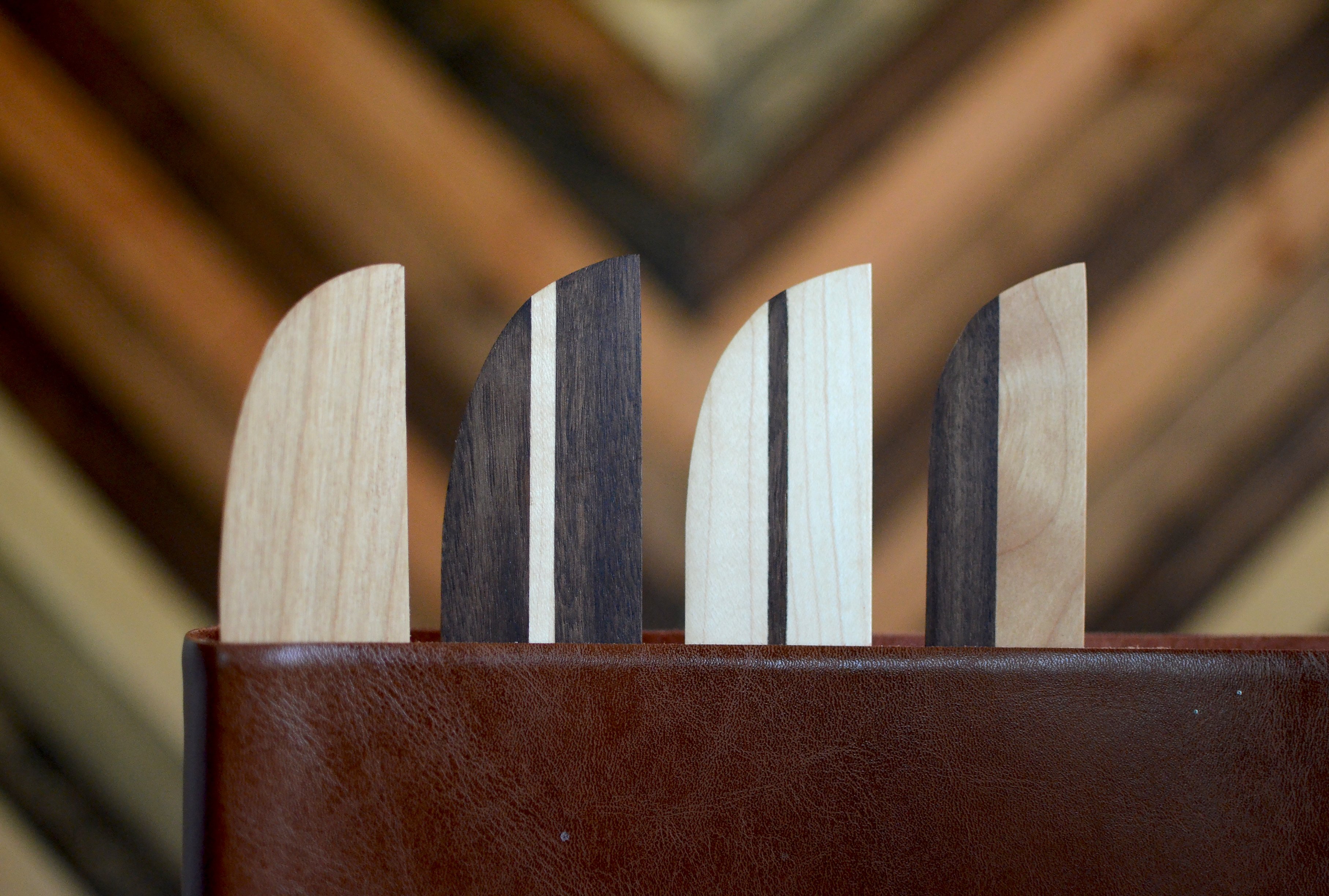 A beautifully handcrafted hardwood bookmark made from Black Walnut, White Maple, and Cherry, showcasing its natural grain and warm finish.