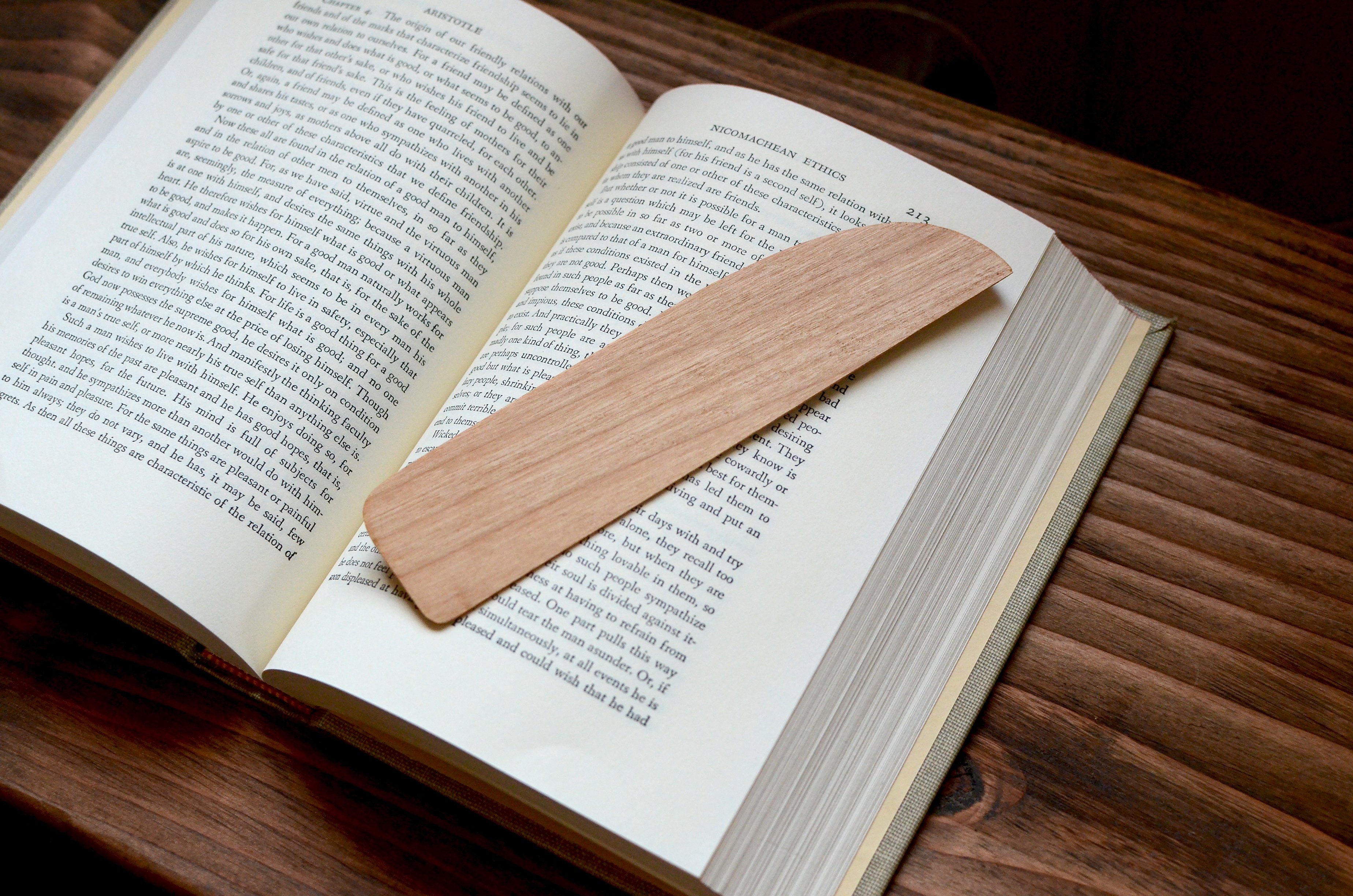 A beautifully handcrafted hardwood bookmark made from Black Walnut, White Maple, and Cherry, showcasing its natural grain and warm finish.