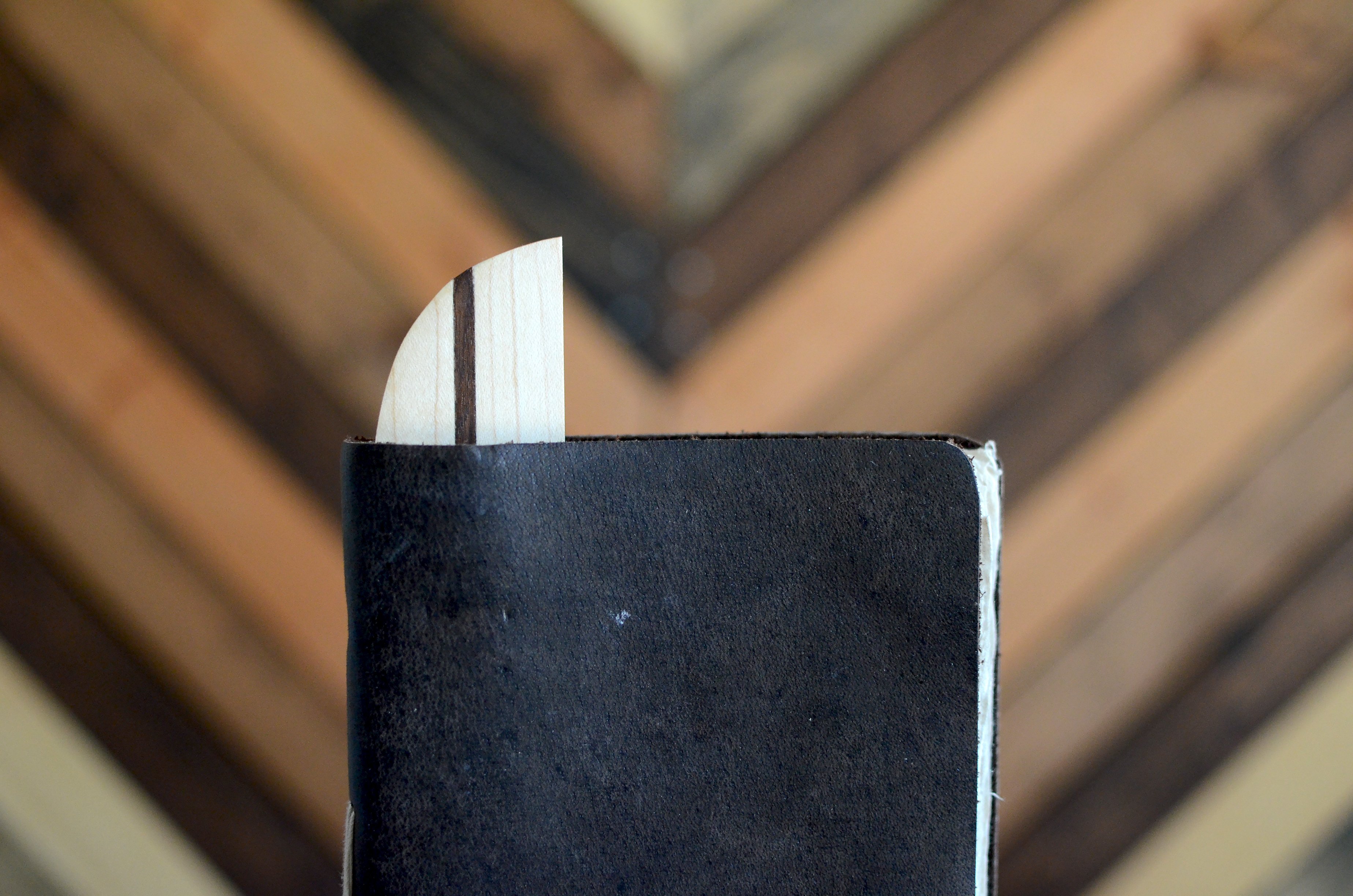 A beautifully handcrafted hardwood bookmark made from Black Walnut, White Maple, and Cherry, showcasing its natural grain and warm finish.