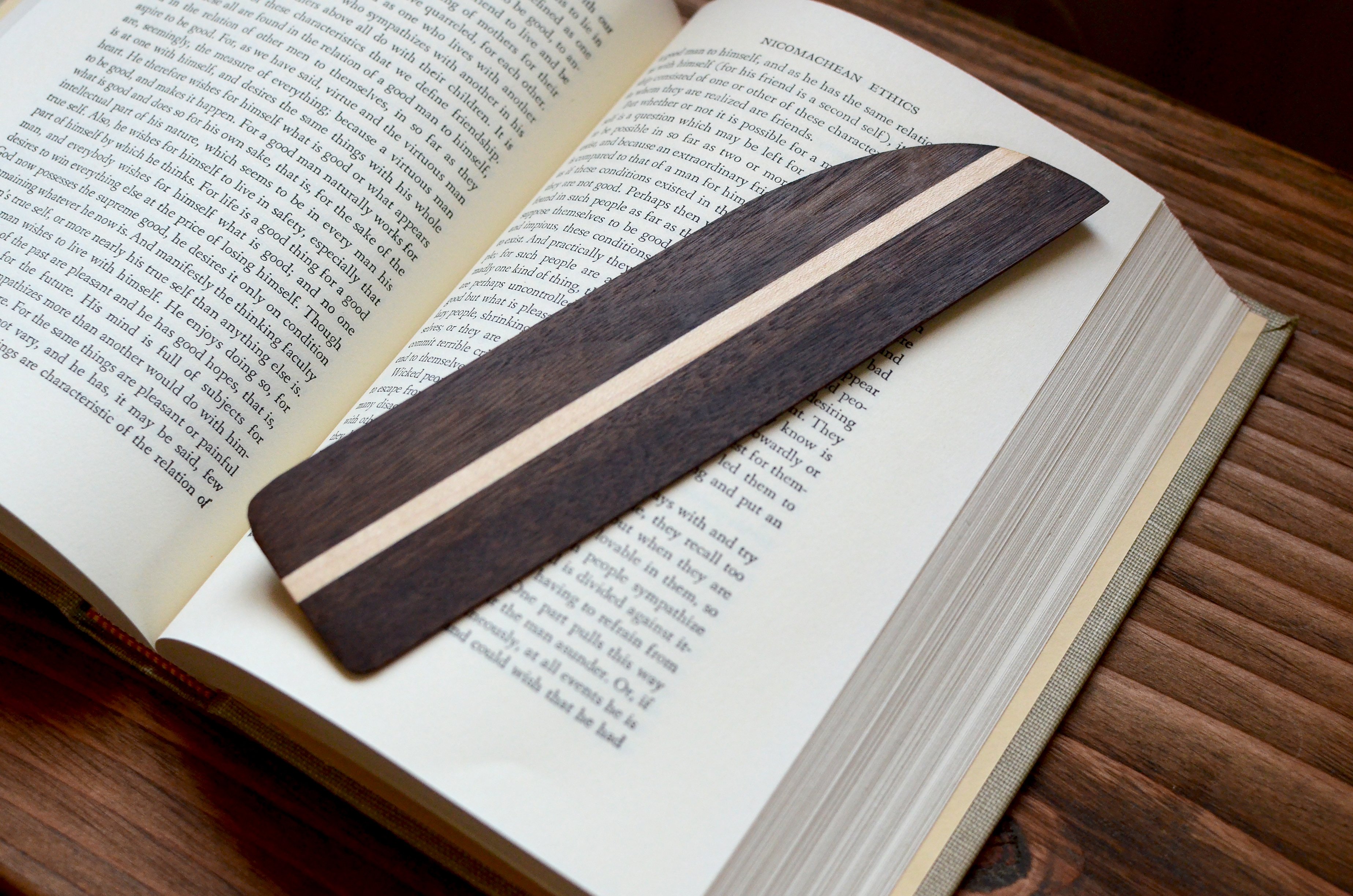 A beautifully handcrafted hardwood bookmark made from Black Walnut, White Maple, and Cherry, showcasing its natural grain and warm finish.