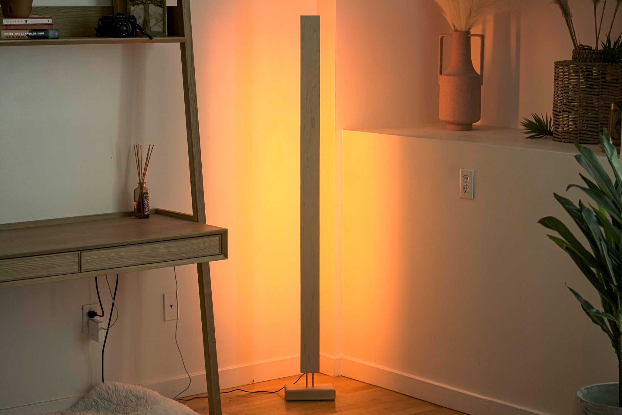 A sleek Hardwood LED Color Floor Lamp made from sustainably sourced Black Walnut and White Maple, featuring a slim design and colorful RGB lighting.