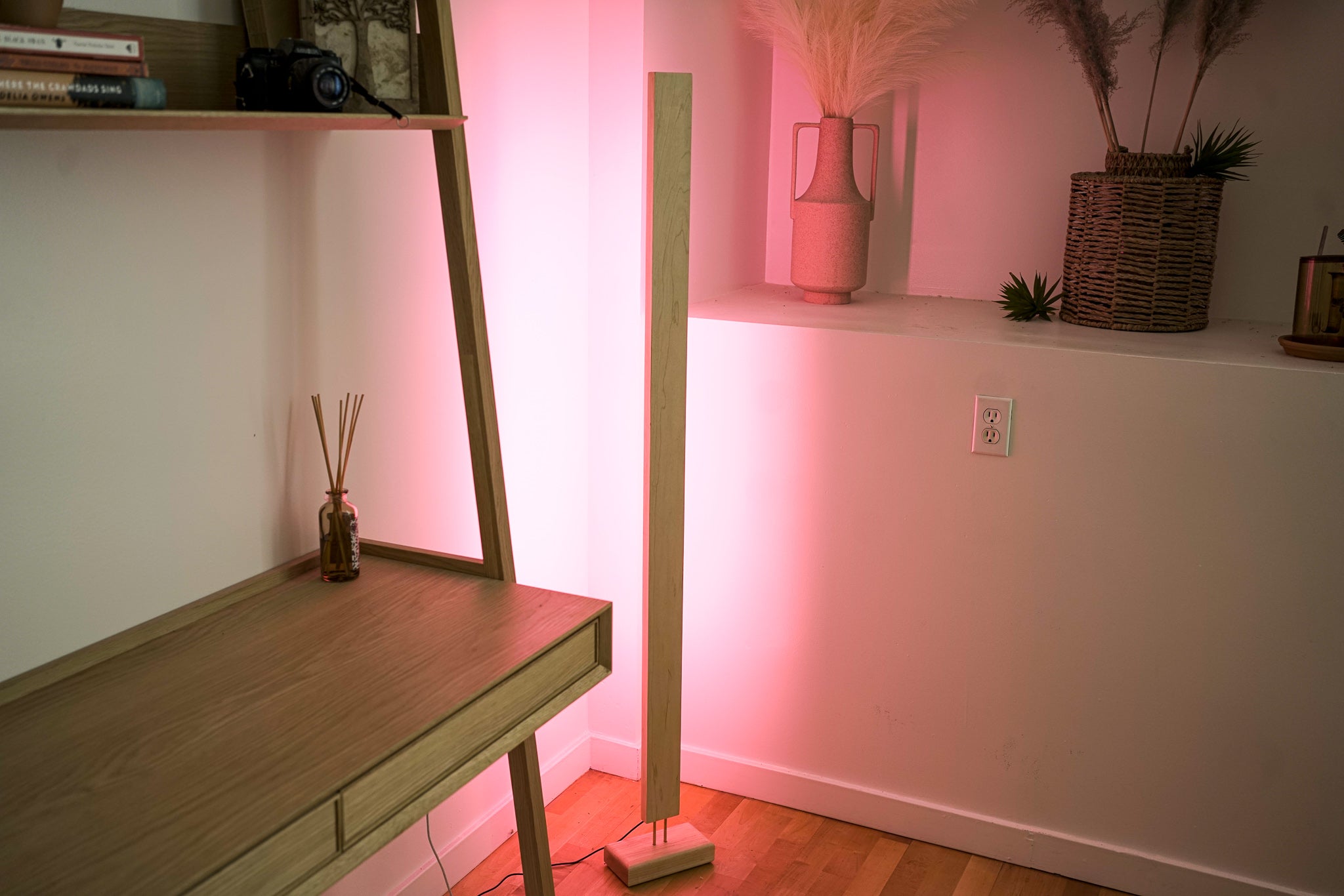 A sleek Hardwood LED Color Floor Lamp made from sustainably sourced Black Walnut and White Maple, featuring a slim design and colorful RGB lighting.