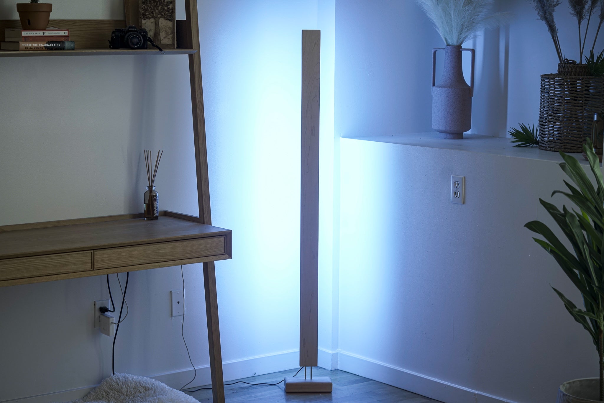 A sleek Hardwood LED Color Floor Lamp made from sustainably sourced Black Walnut and White Maple, featuring a slim design and colorful RGB lighting.