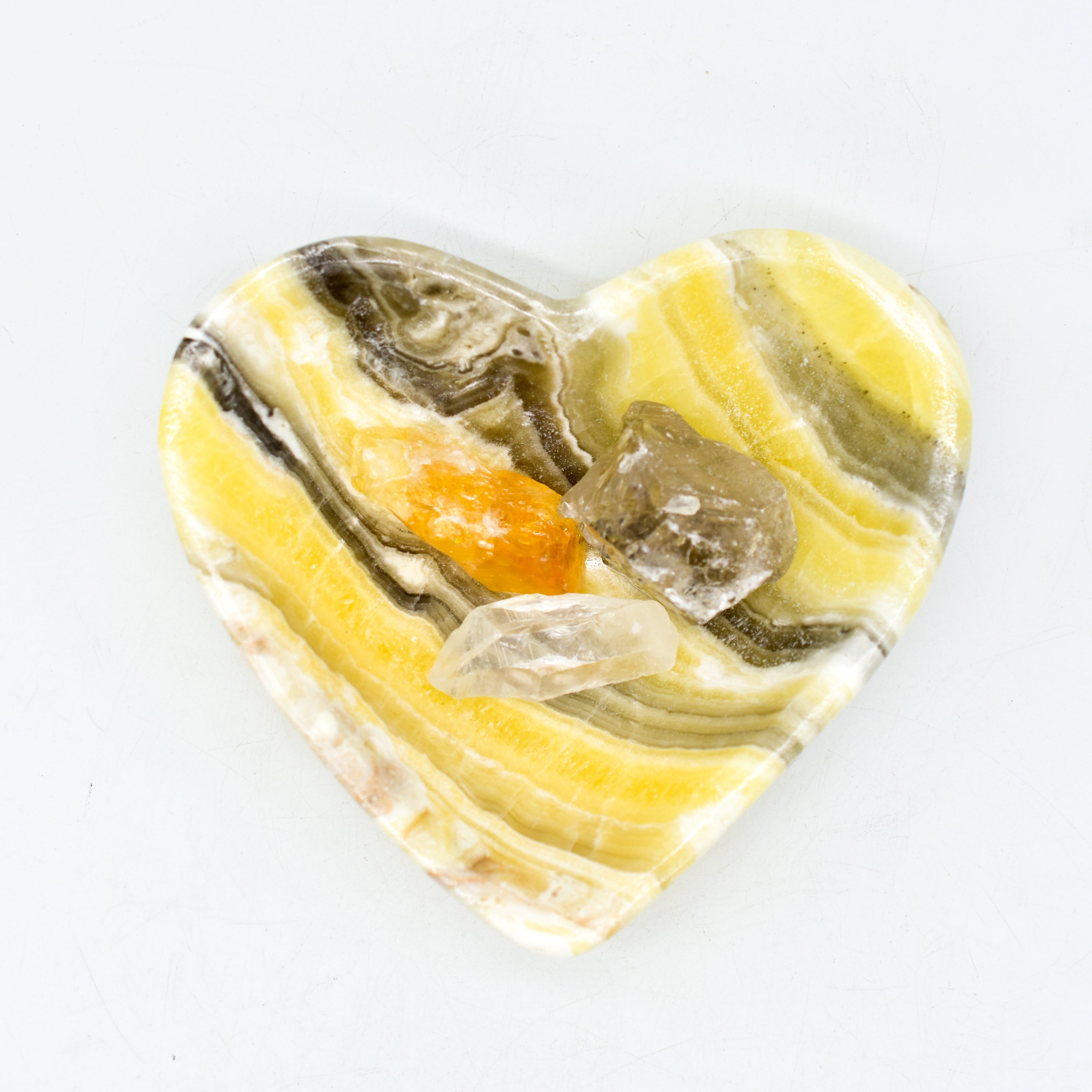 A beautifully handcrafted heart-shaped onyx bowl in zebra, amber, and white colors, showcasing its unique craftsmanship.