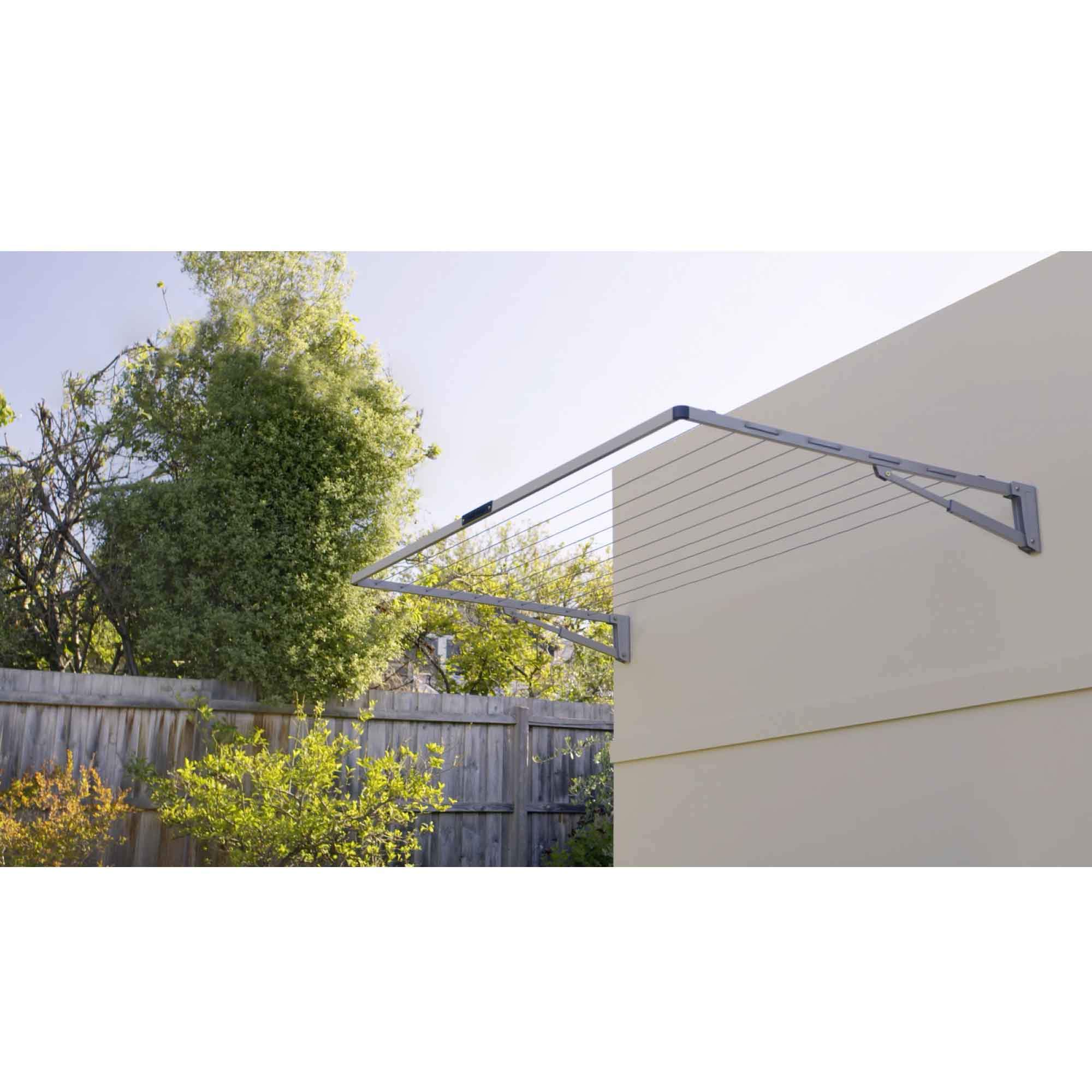 Hills Folding Clothesline Everyday Single in Autumn Stone, wall-mounted with clothes hanging on it.