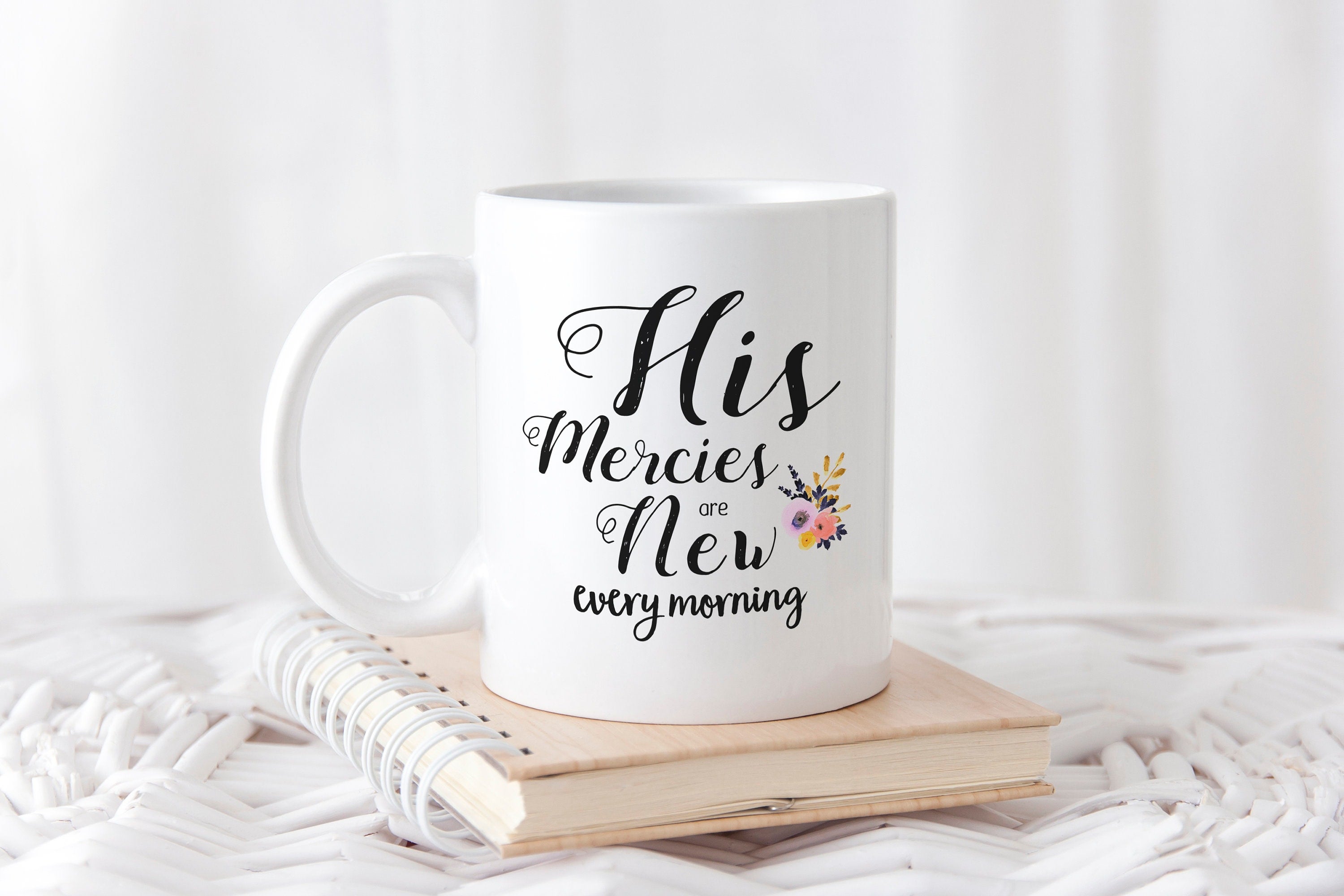 White coffee mug with hand-lettered scripture 'His Mercies are New Every Morning' printed on both sides, showcasing an inspirational design.