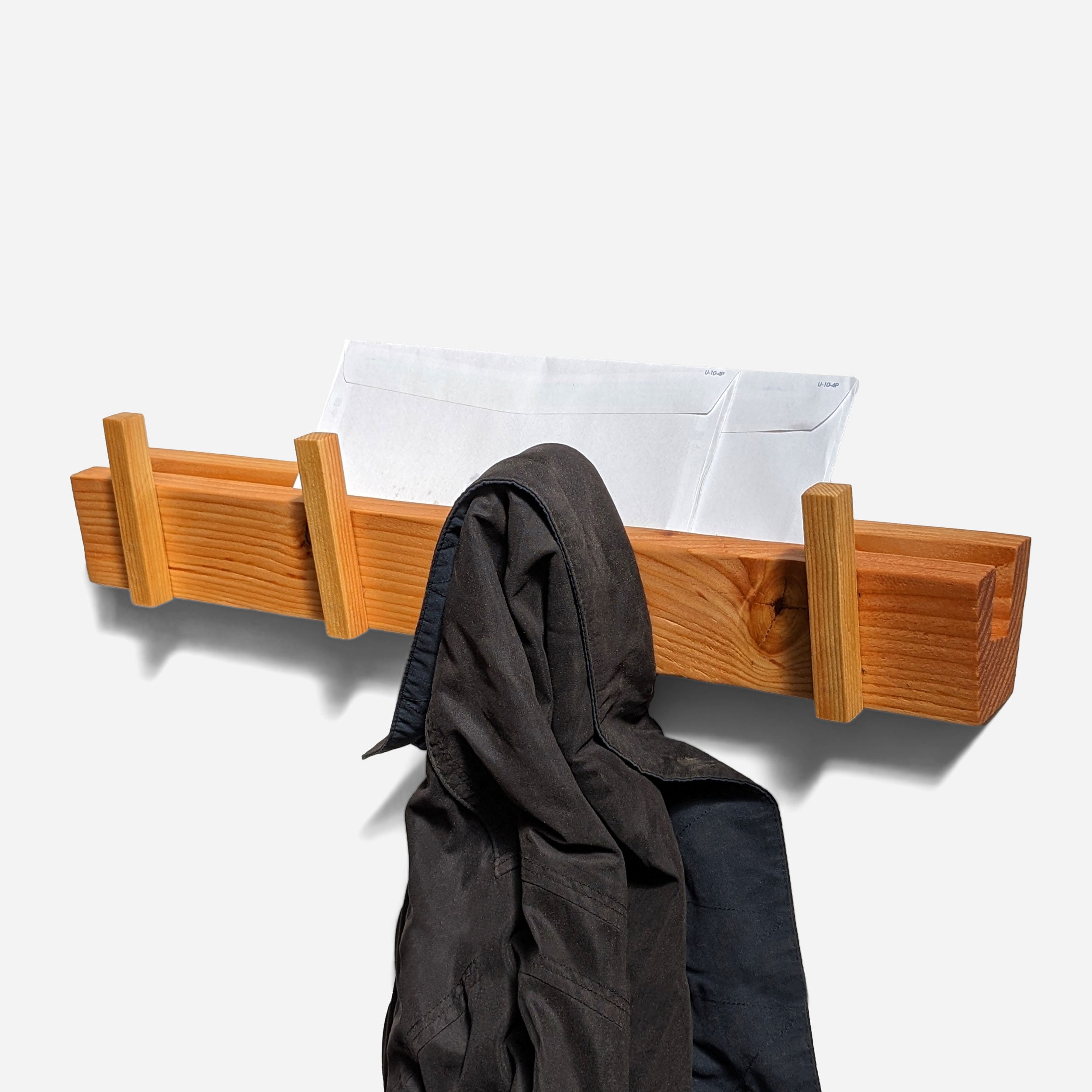 Hooked coatrack made from upcycled wood with mail storage, featuring a natural finish and unique color variations.