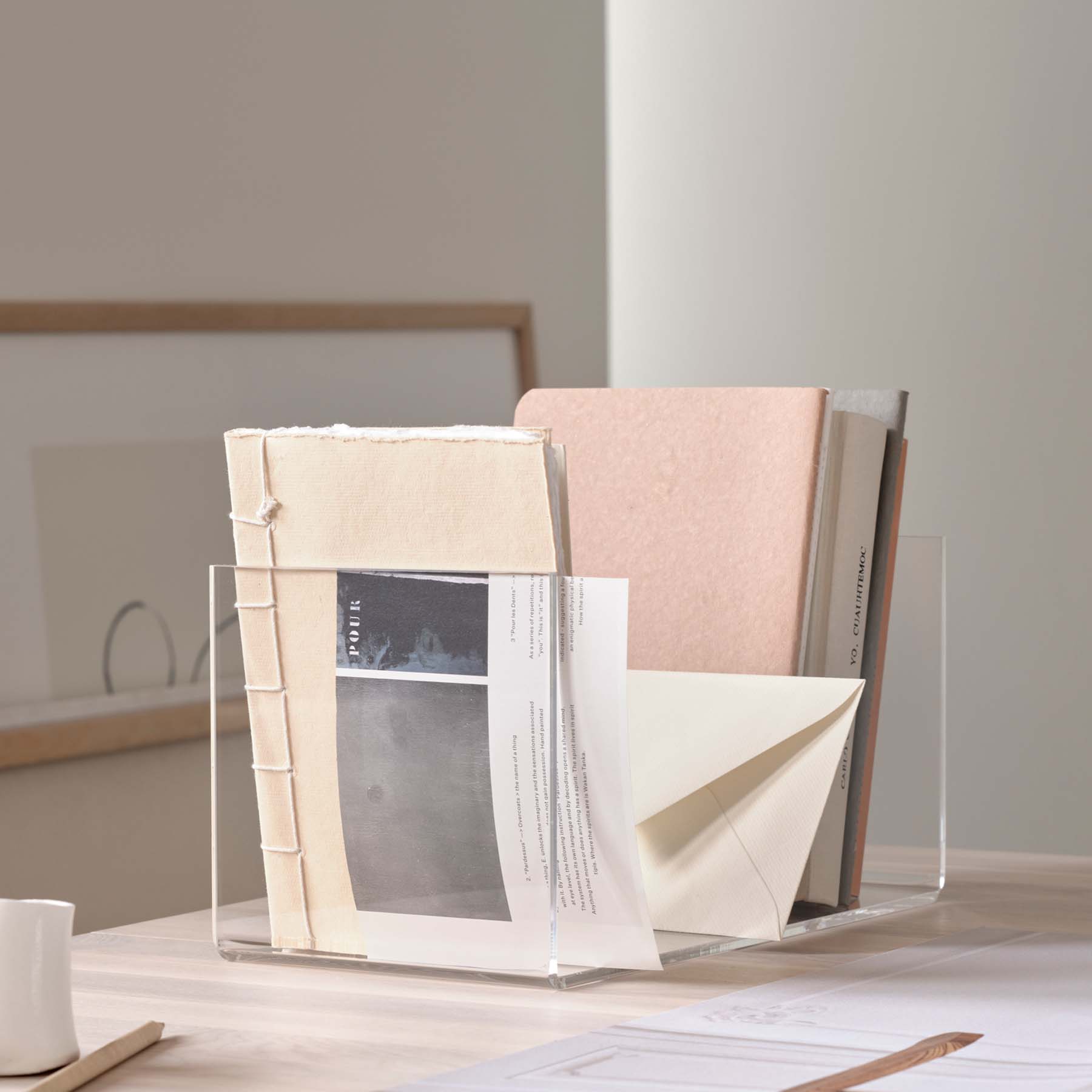 A minimalistic acrylic book holder named Holding Wide, showcasing its transparent design and versatile storage options.