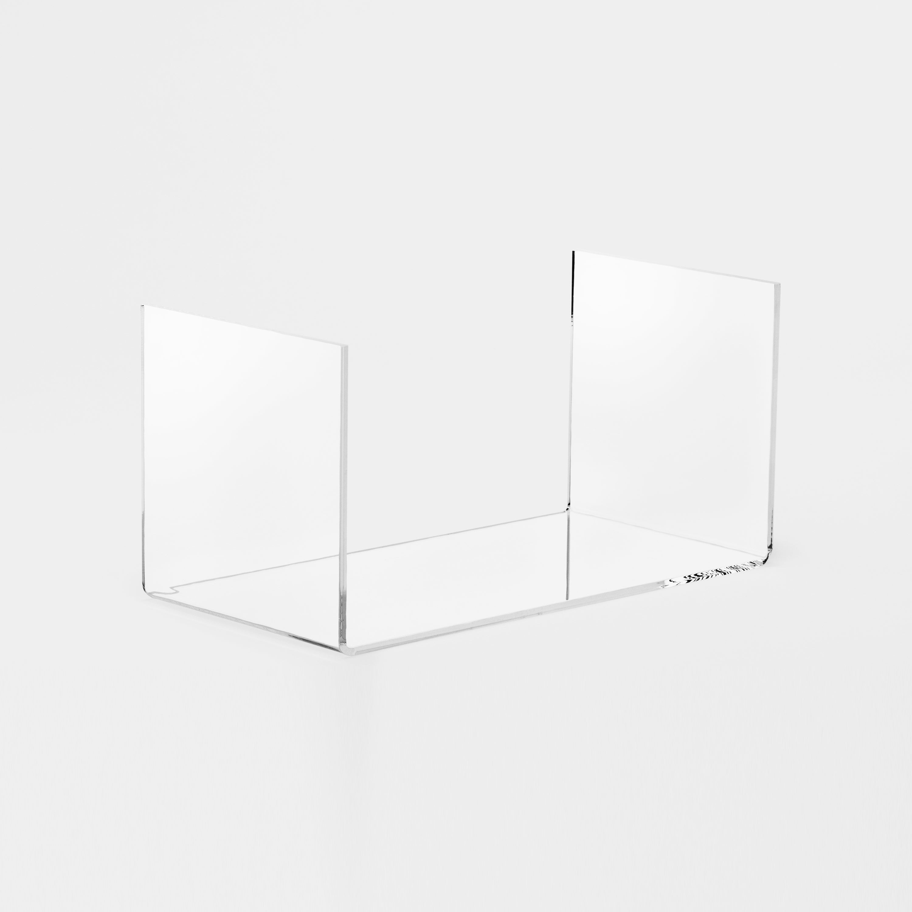 A minimalistic acrylic book holder named Holding Wide, showcasing its transparent design and versatile storage options.