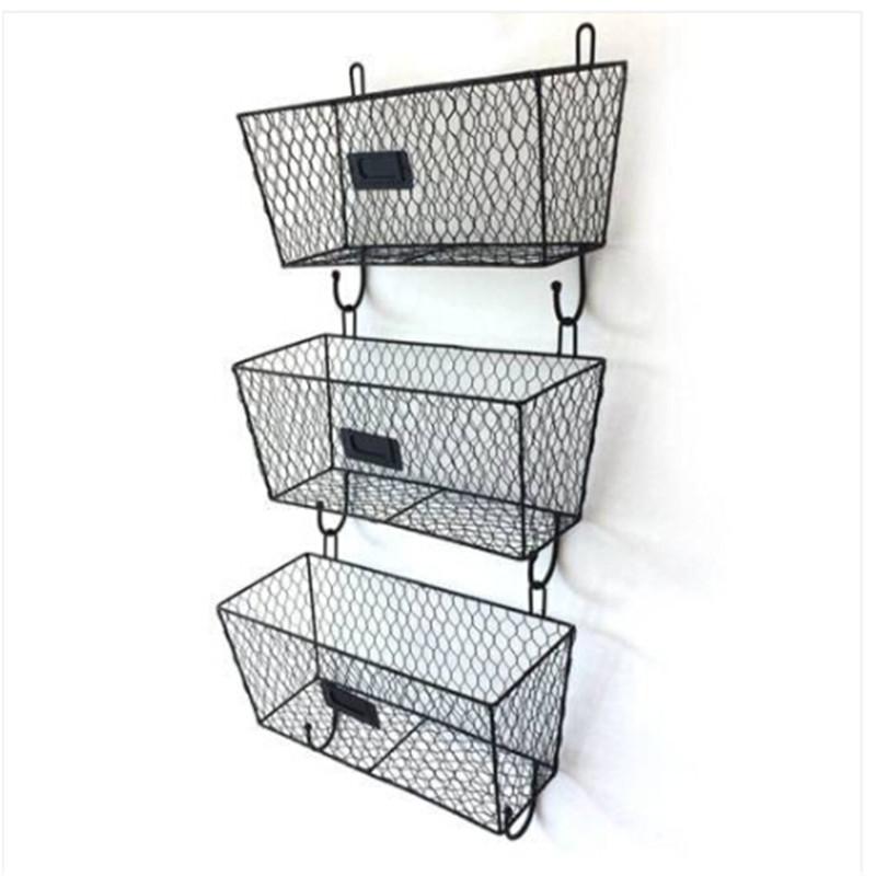 Three vintage black wire letter mail mount metal rack baskets mounted on a wall, showcasing their stylish design and practical storage capabilities.