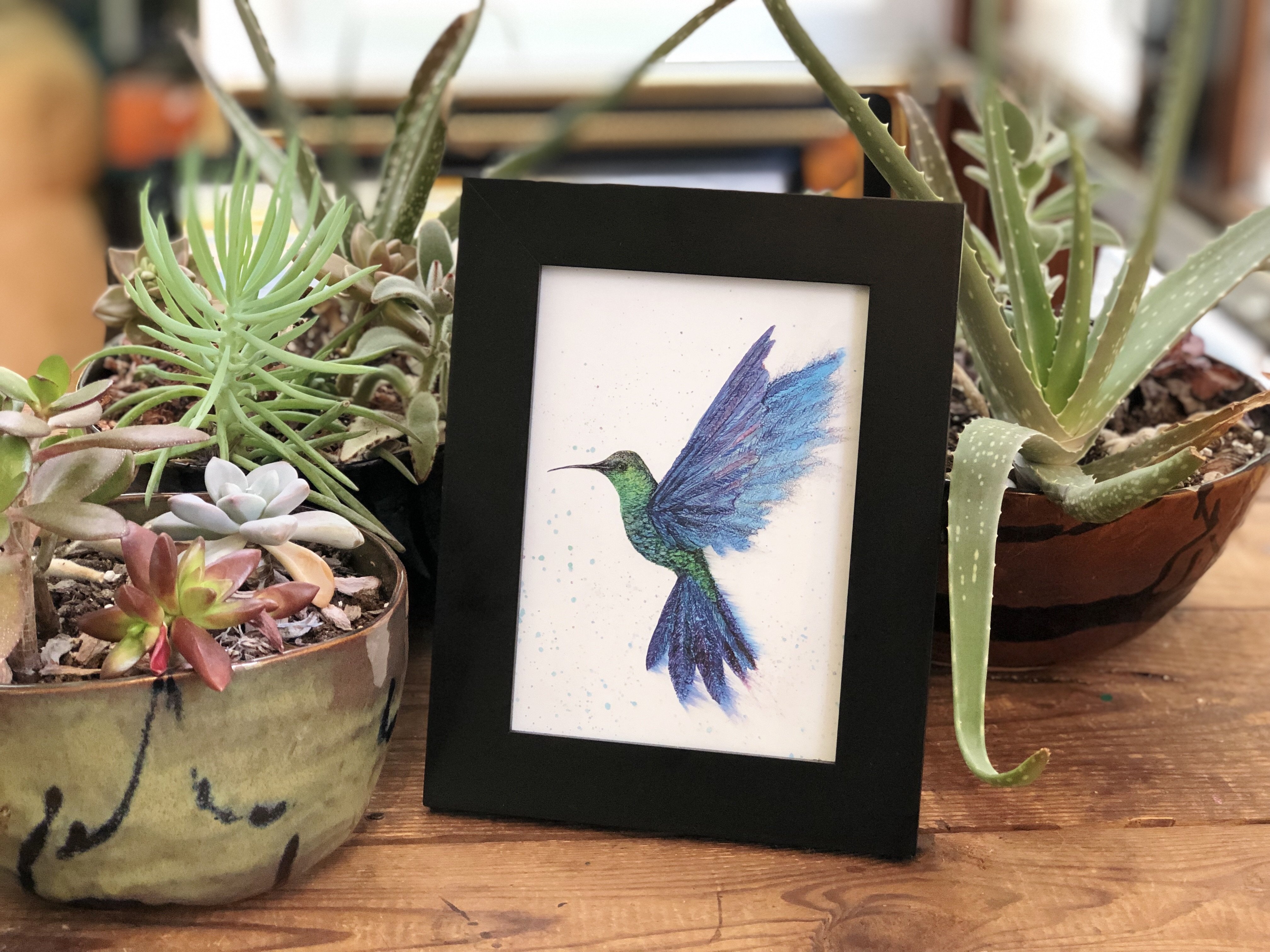 A beautifully designed greeting card featuring a graceful hummingbird in flight, created with alcohol inks, showcasing vibrant colors and intricate details.