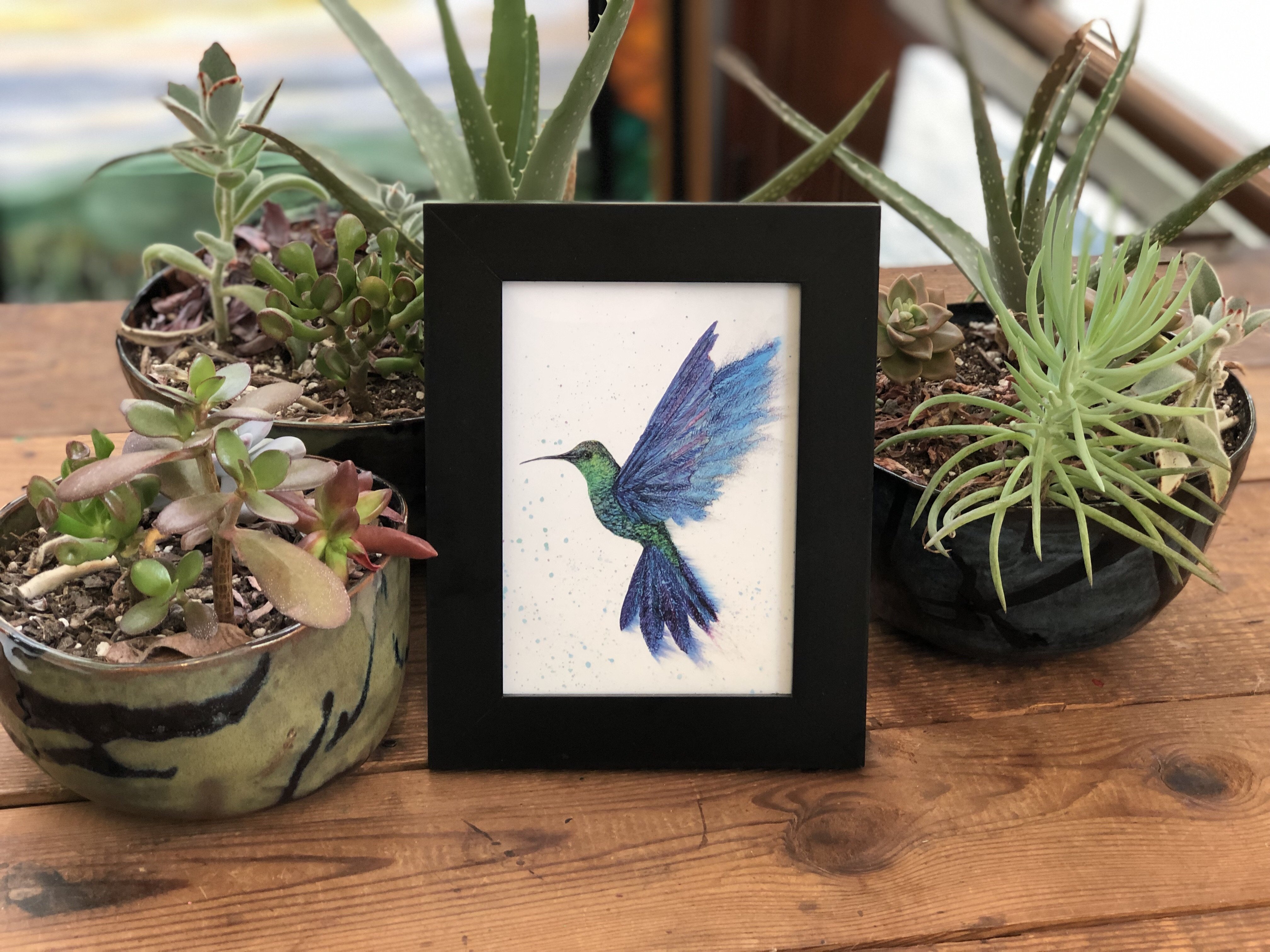 A beautifully designed greeting card featuring a graceful hummingbird in flight, created with alcohol inks, showcasing vibrant colors and intricate details.